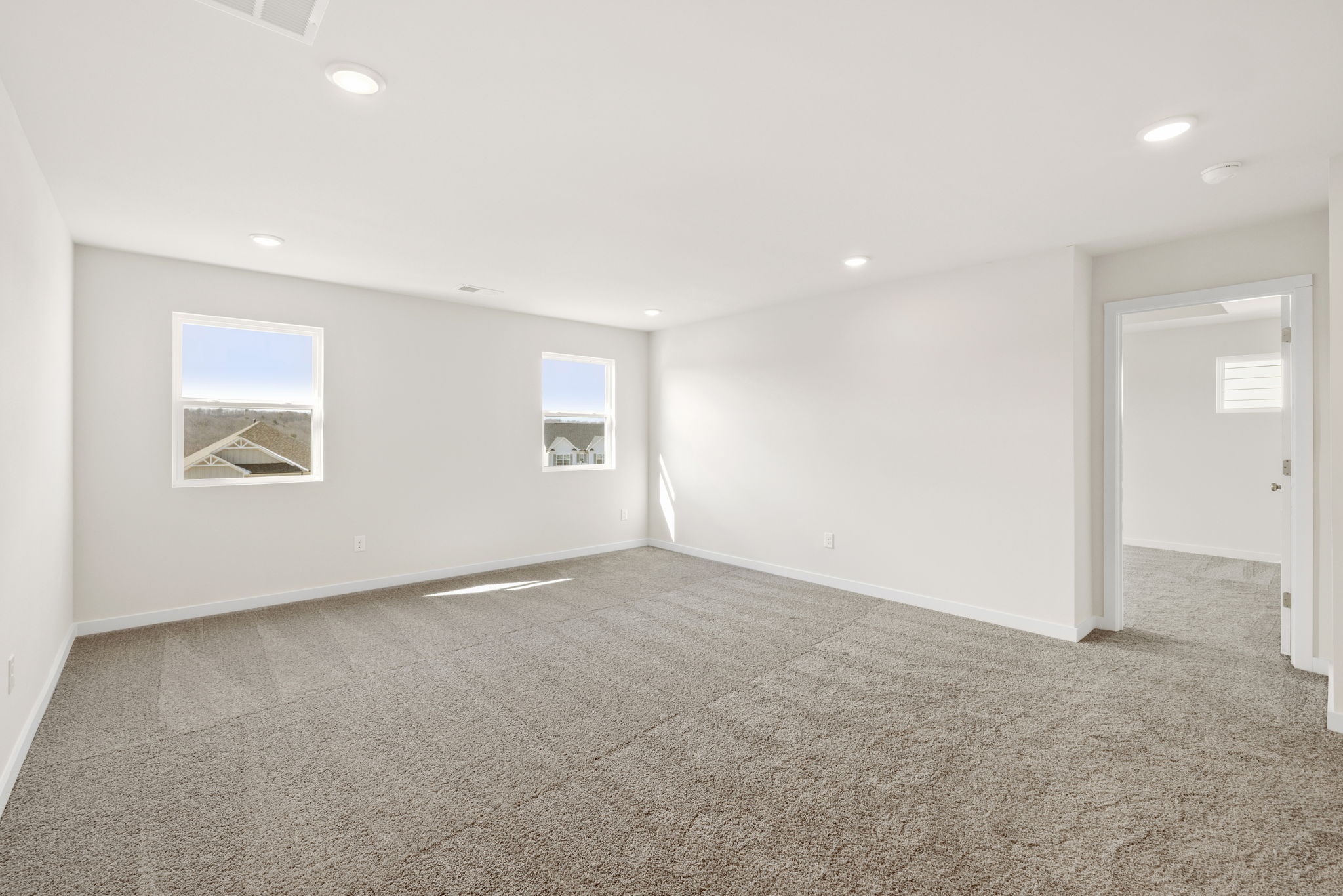 A room with a carpet and a door.