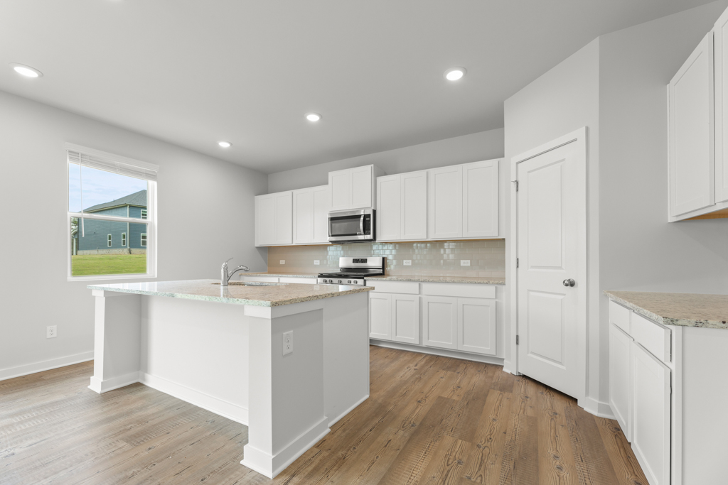 A kitchen with white cabinets.
