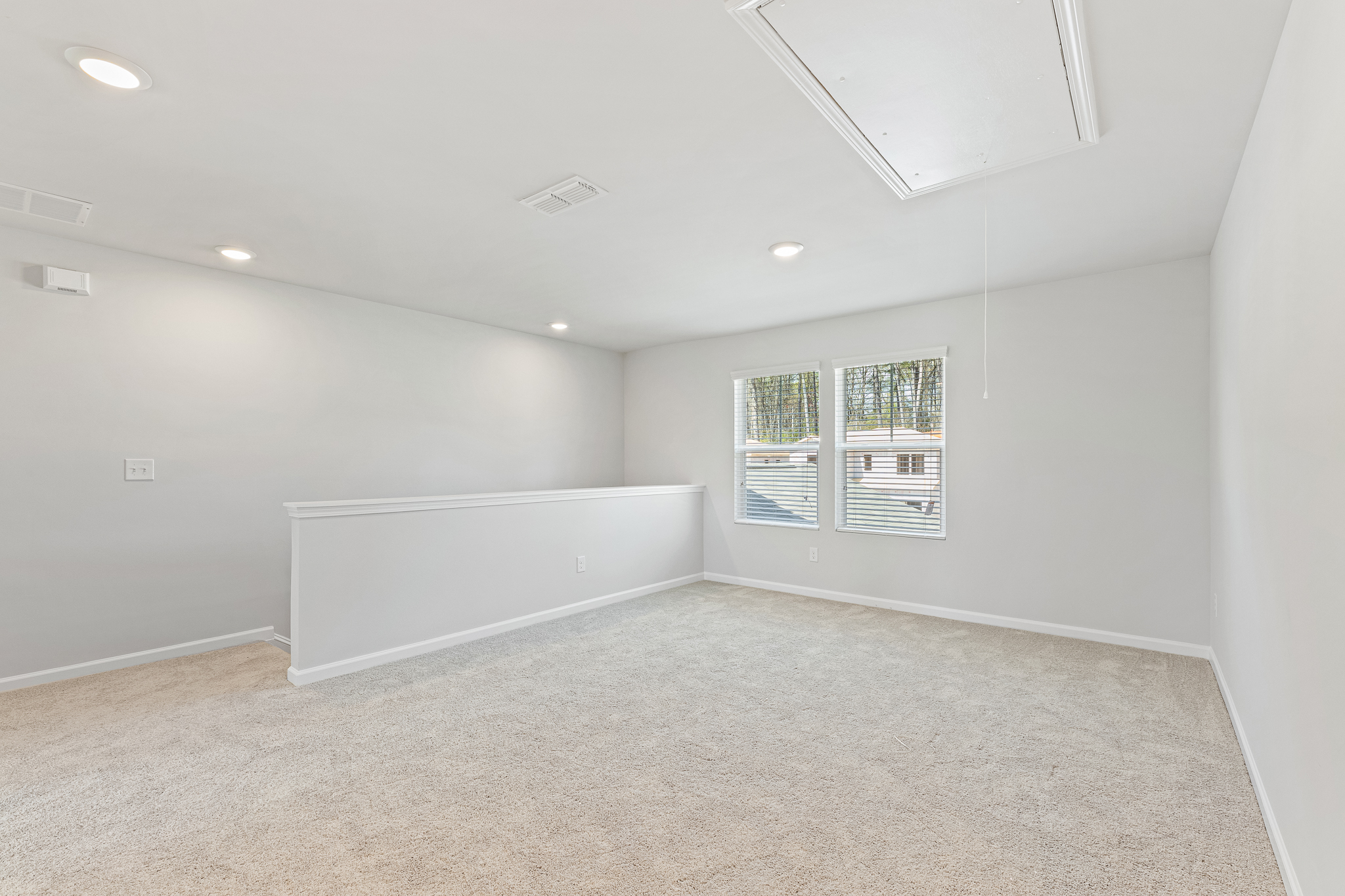 A room with a white wall and a window.