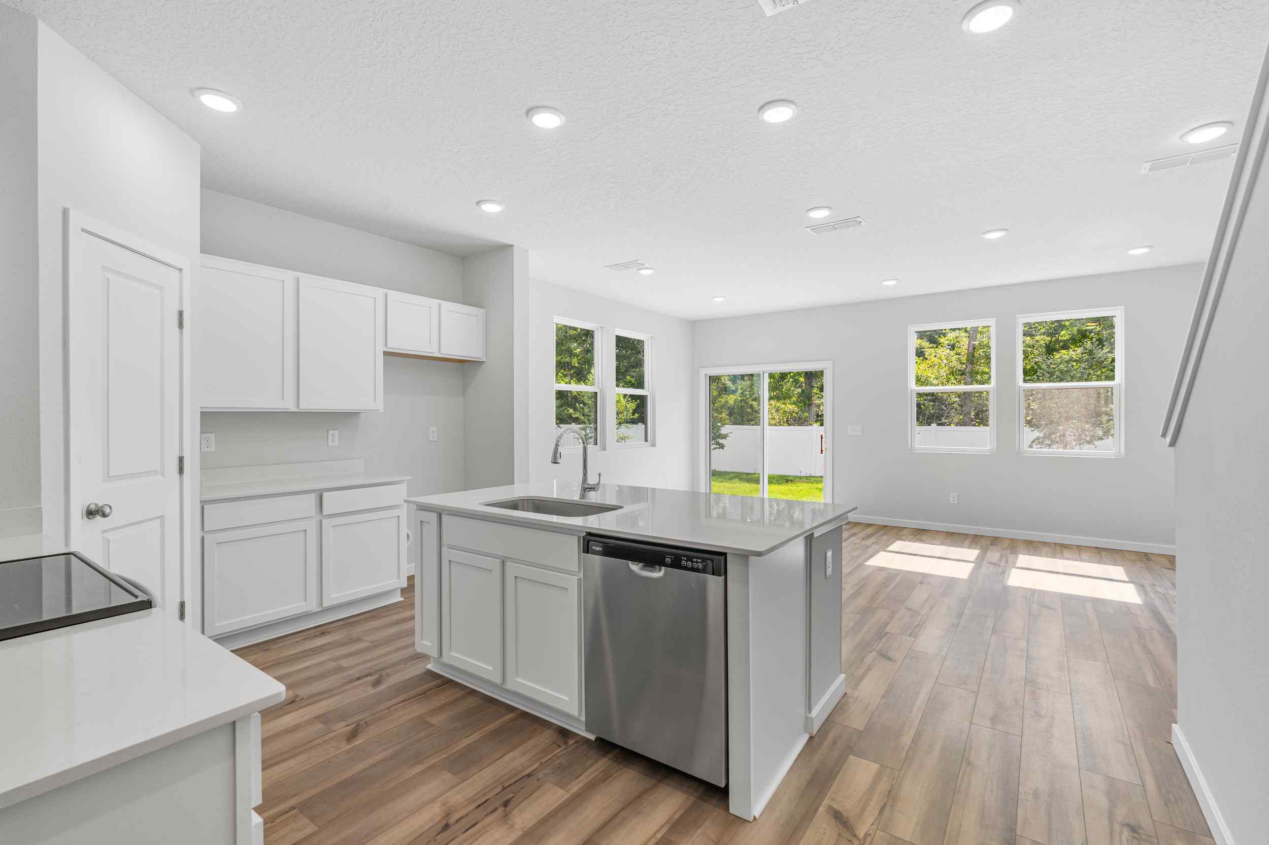 A kitchen with white cabinets.