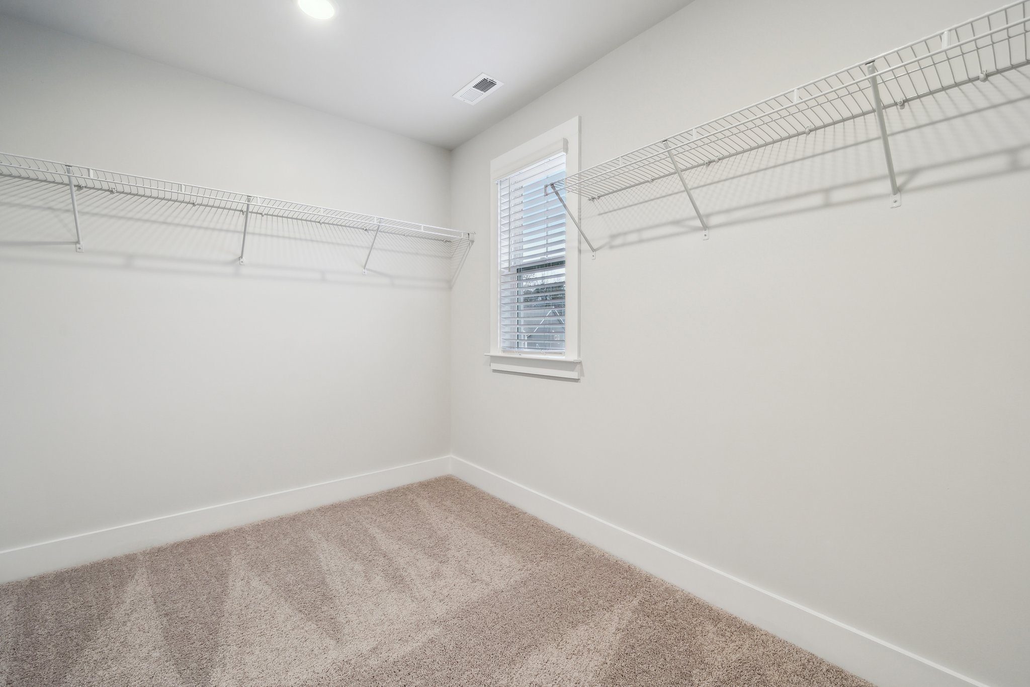 A room with a window and a rug.