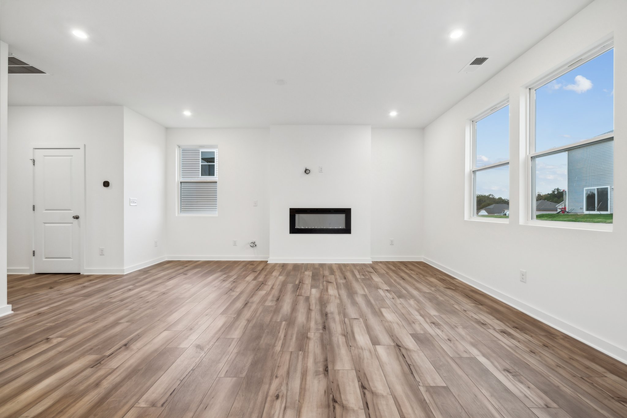A room with a wood floor and a wood floor with a window.