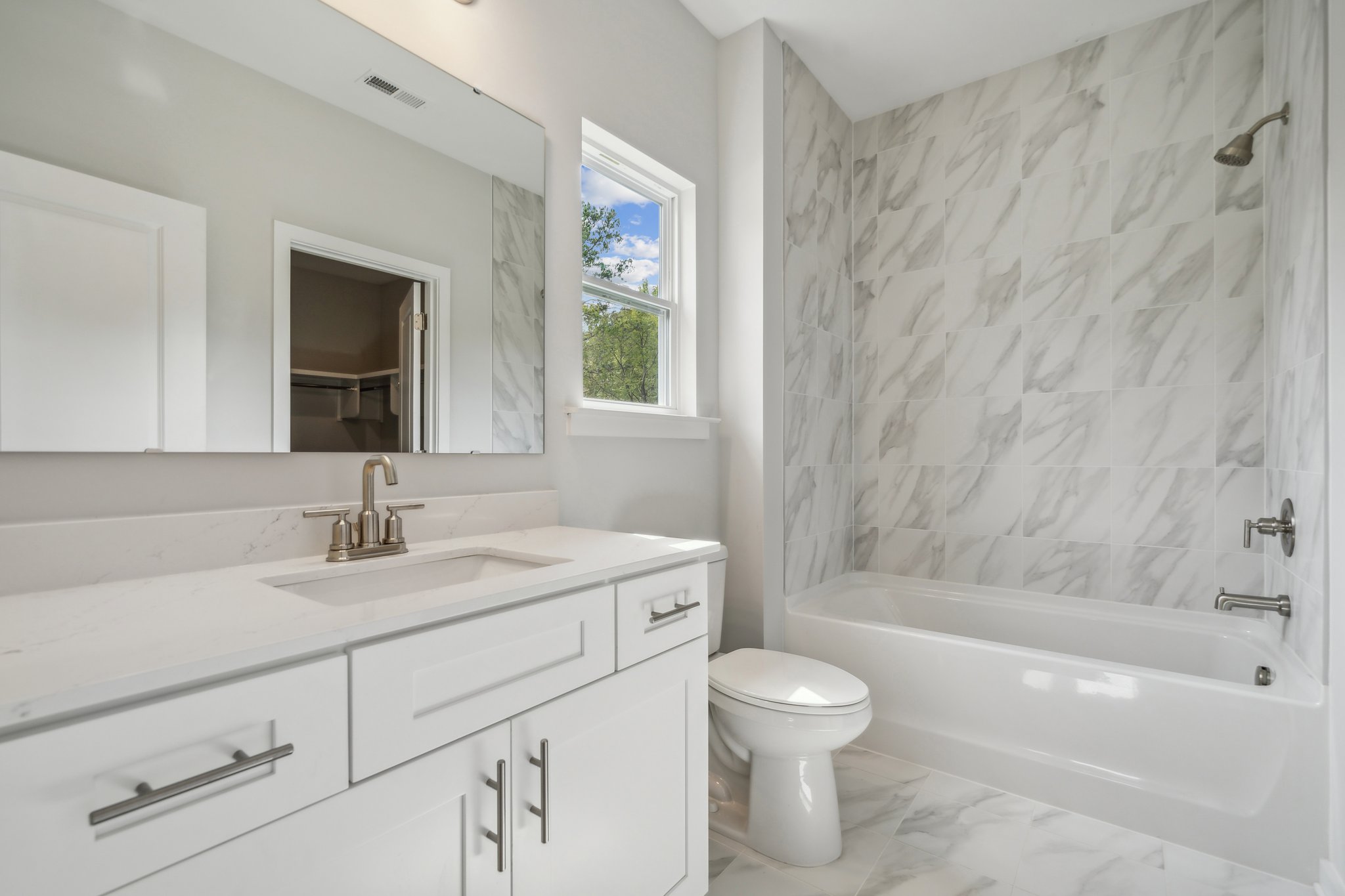 A bathroom with a tub sink and toilet.