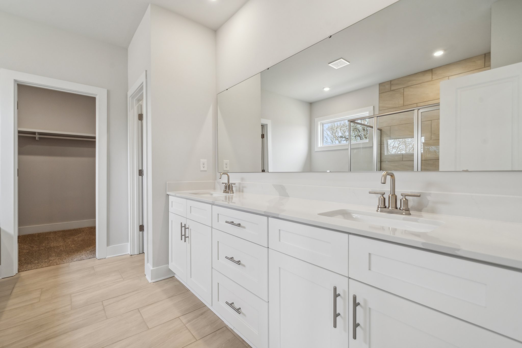A bathroom with white cabinets.