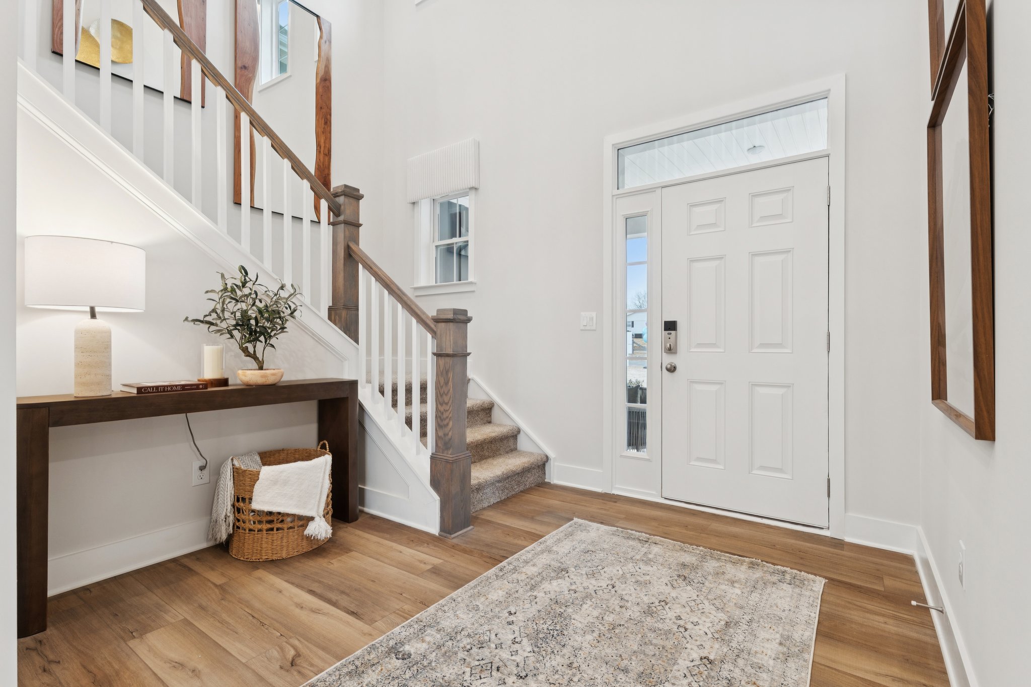 A room with a rug and a table with a lamp on it.