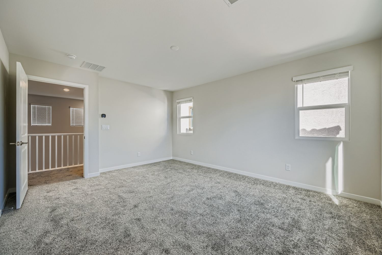 A room with a carpet and windows.