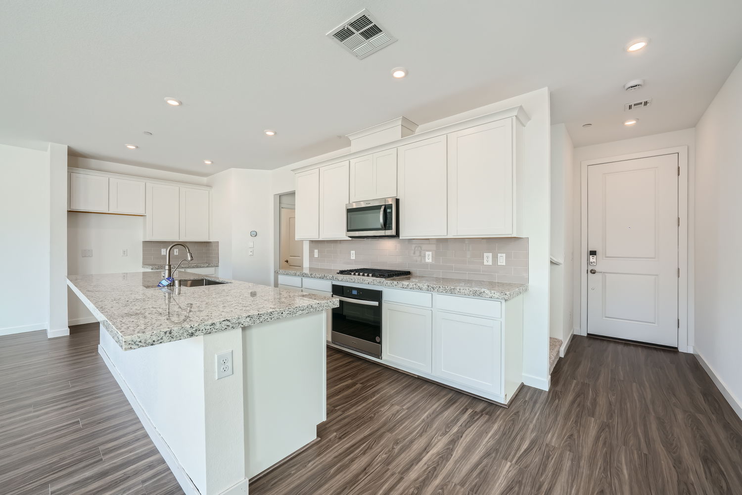 A kitchen with white cabinets.