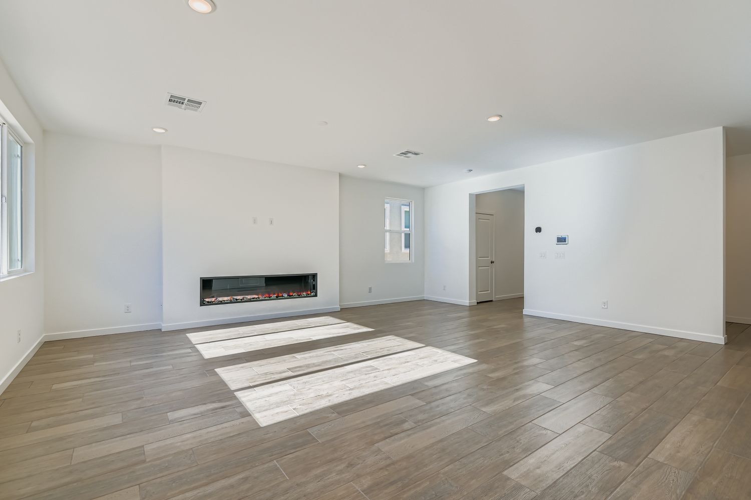 A room with a wood floor and a rug.