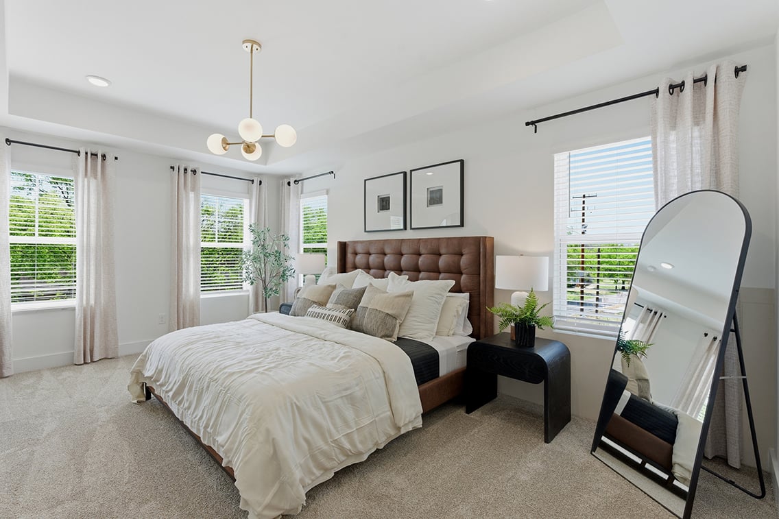 A bedroom with a large mirror.