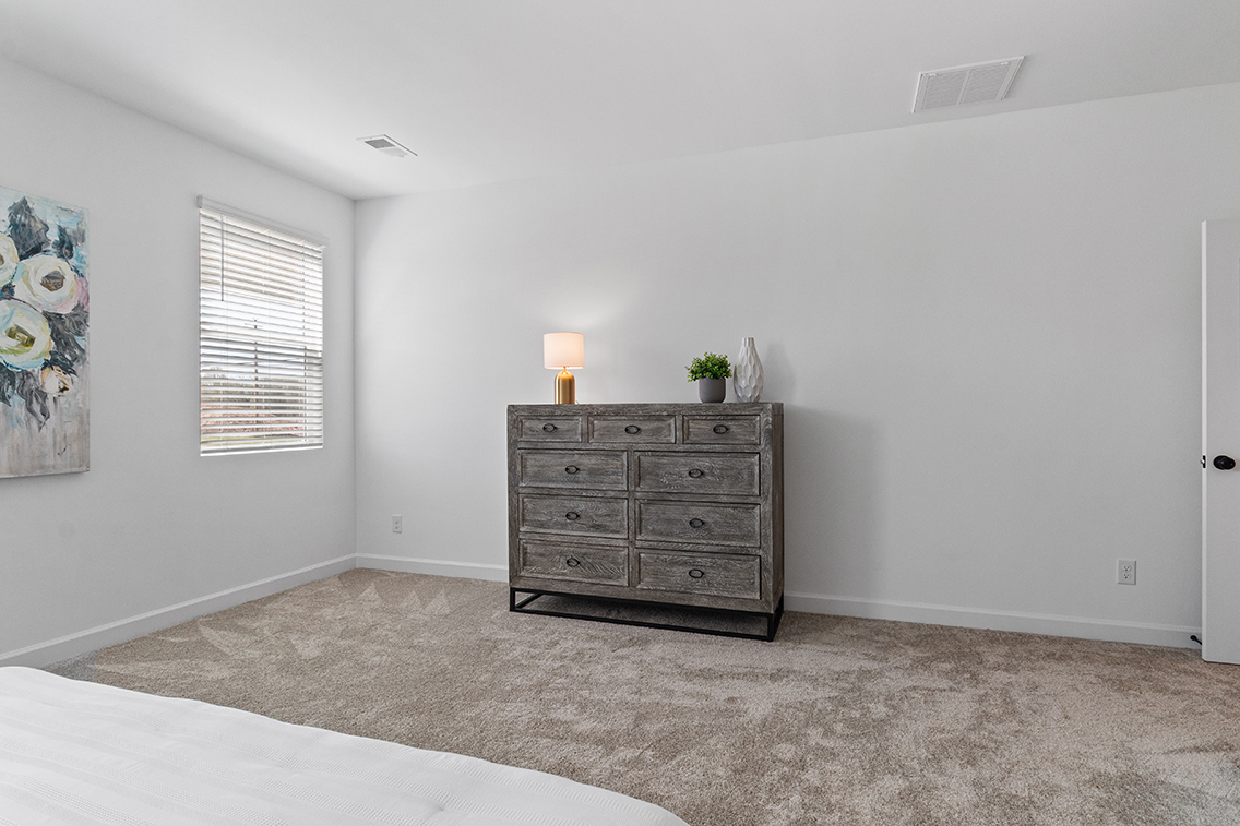 A room with a dresser and a lamp.