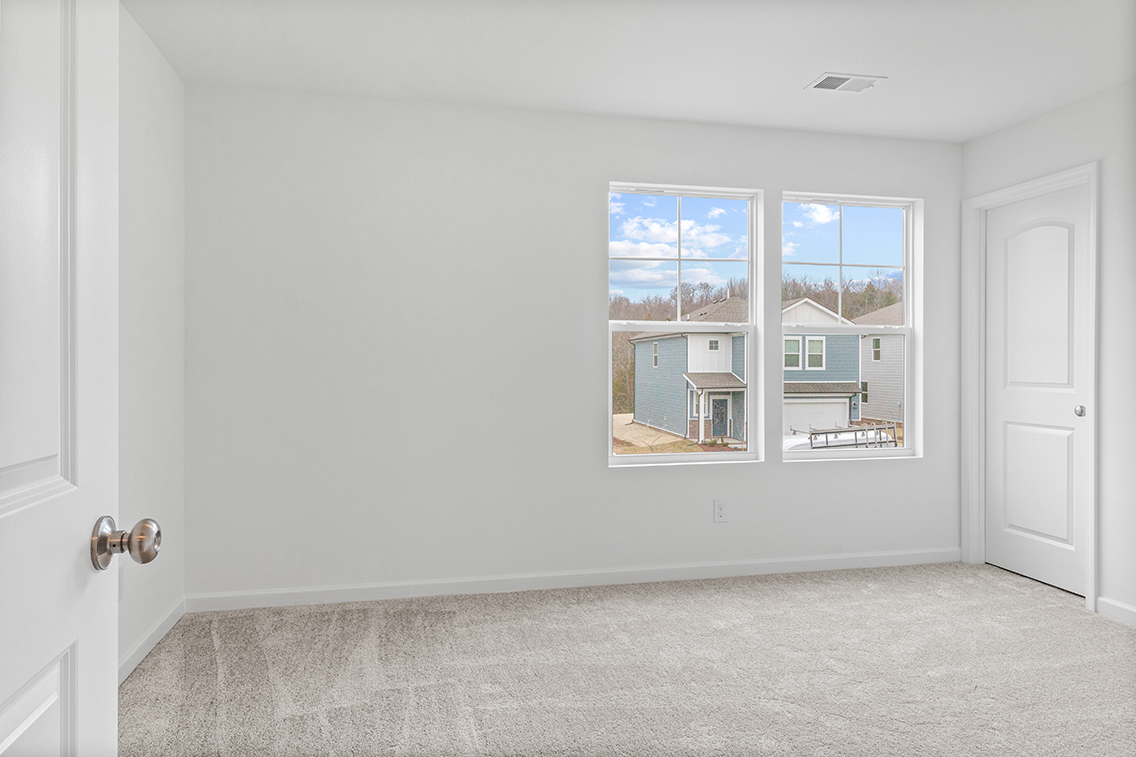 A room with a window and a door with a view of the city.