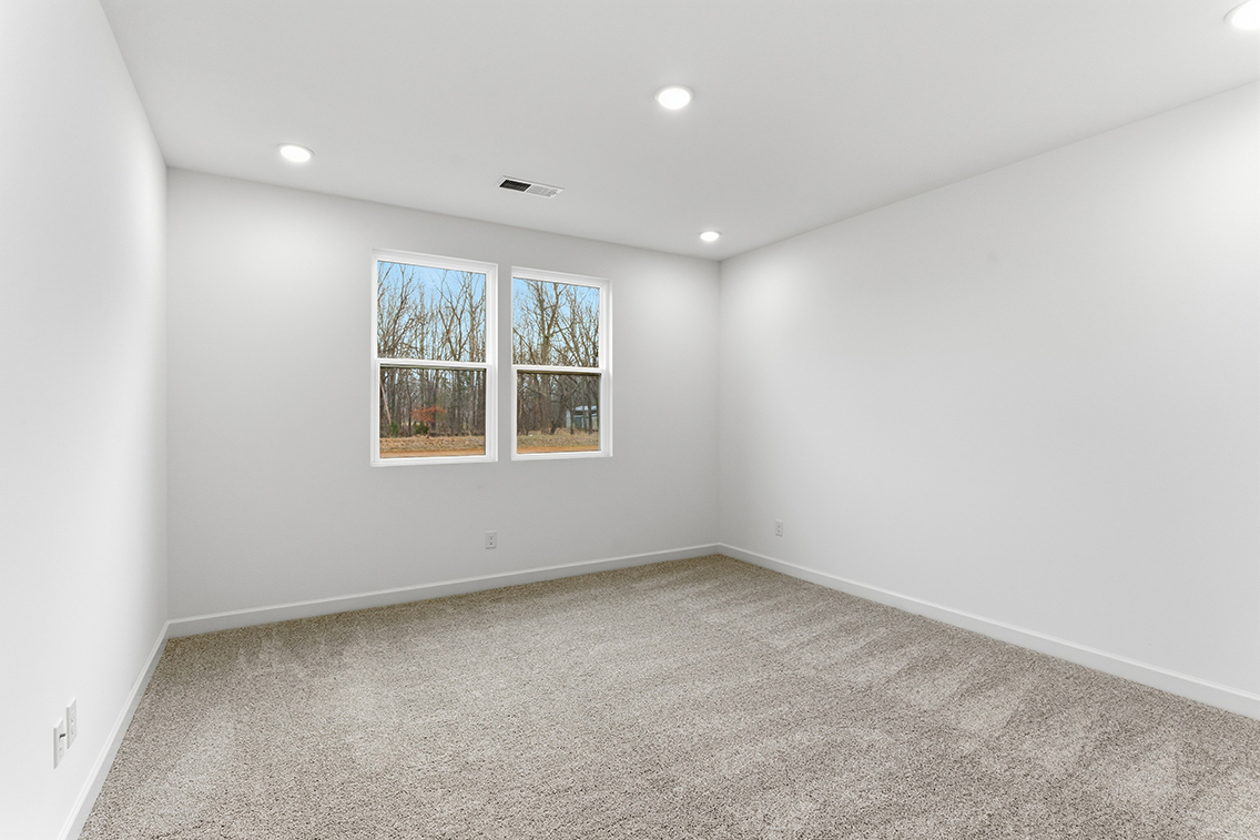 A room with a window and a white wall.