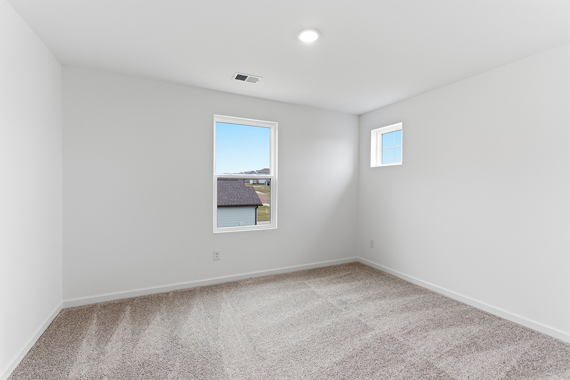 A room with a window and carpet.