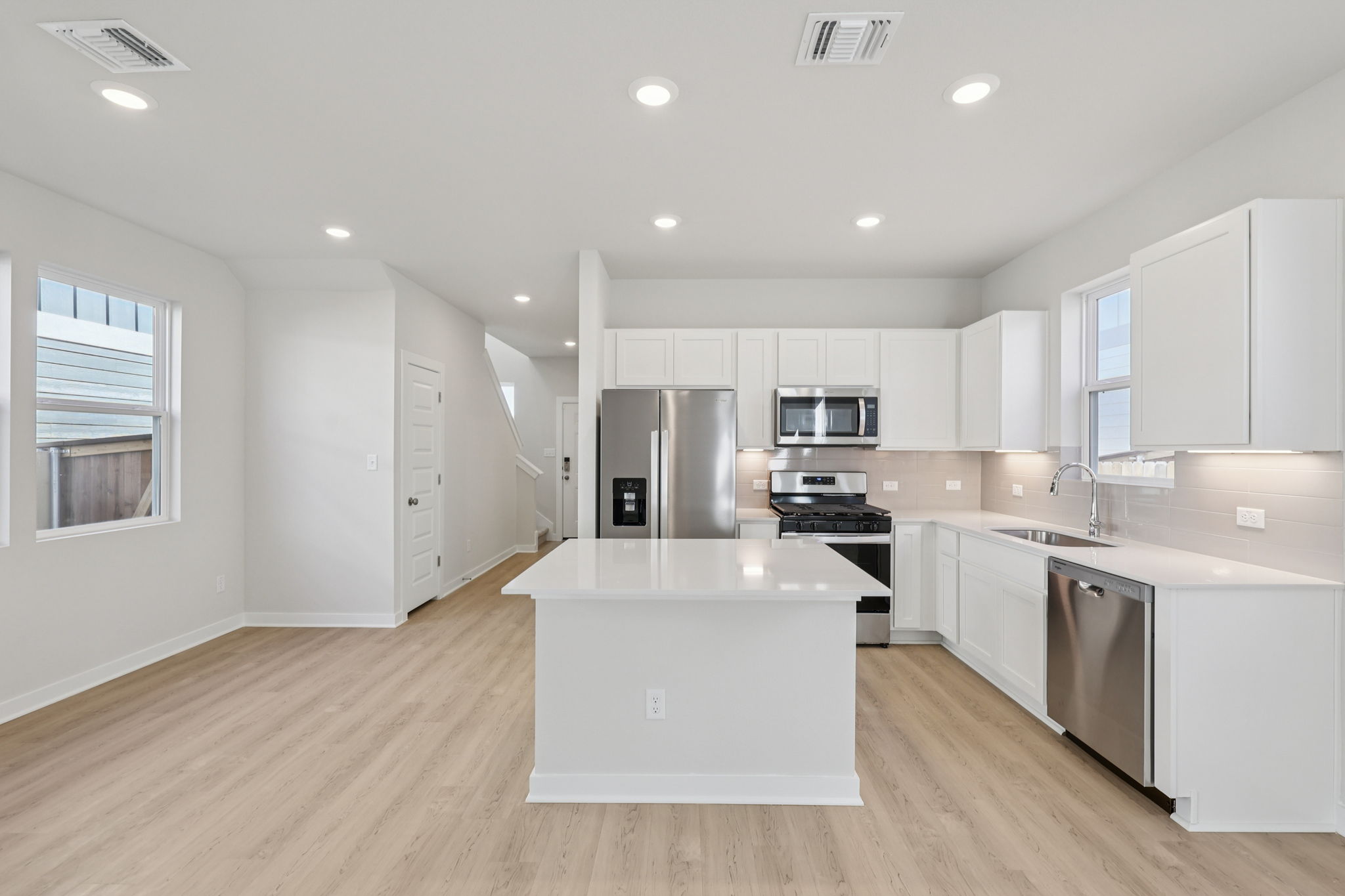 A kitchen with white cabinets.