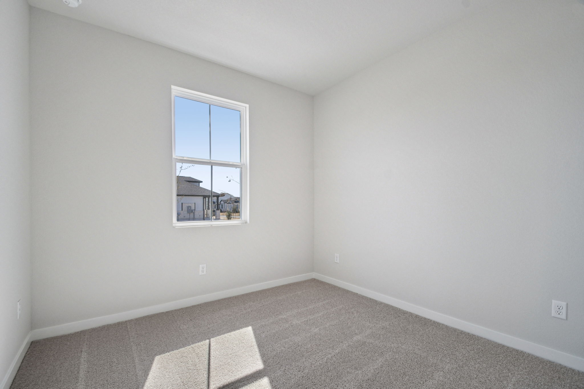 A room with a window and a rug.