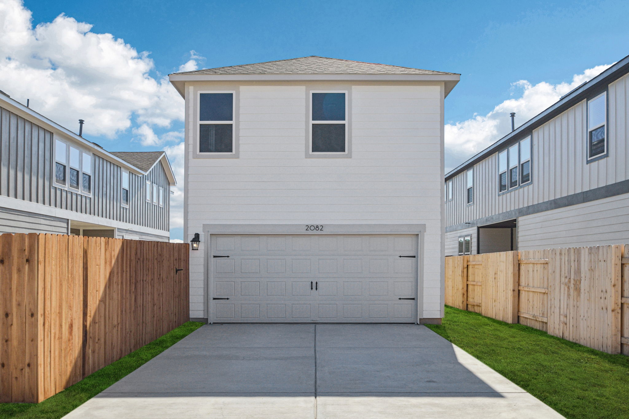 A white garage in a backyard.