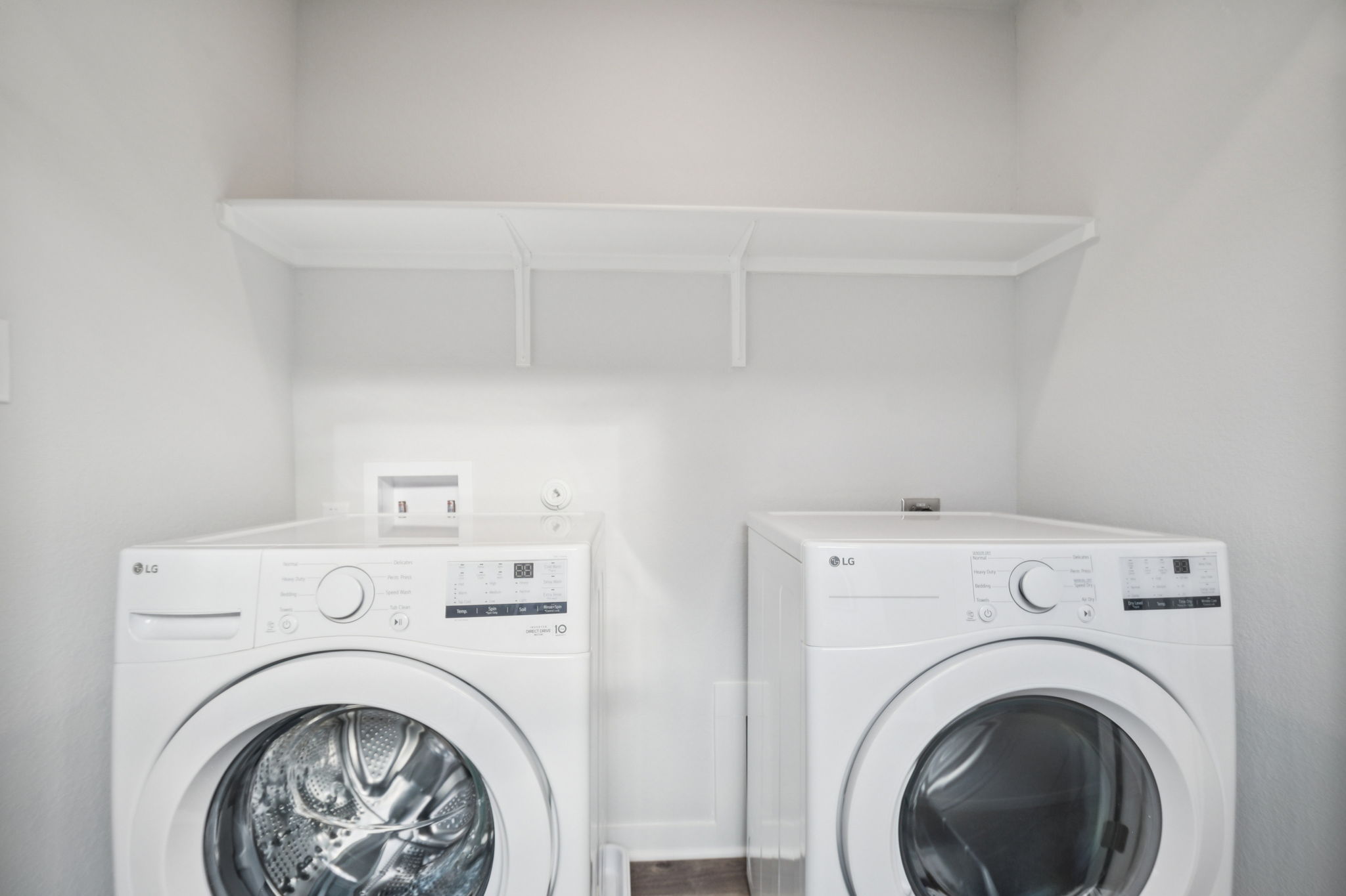 A white laundry room with a white washer and dryer.