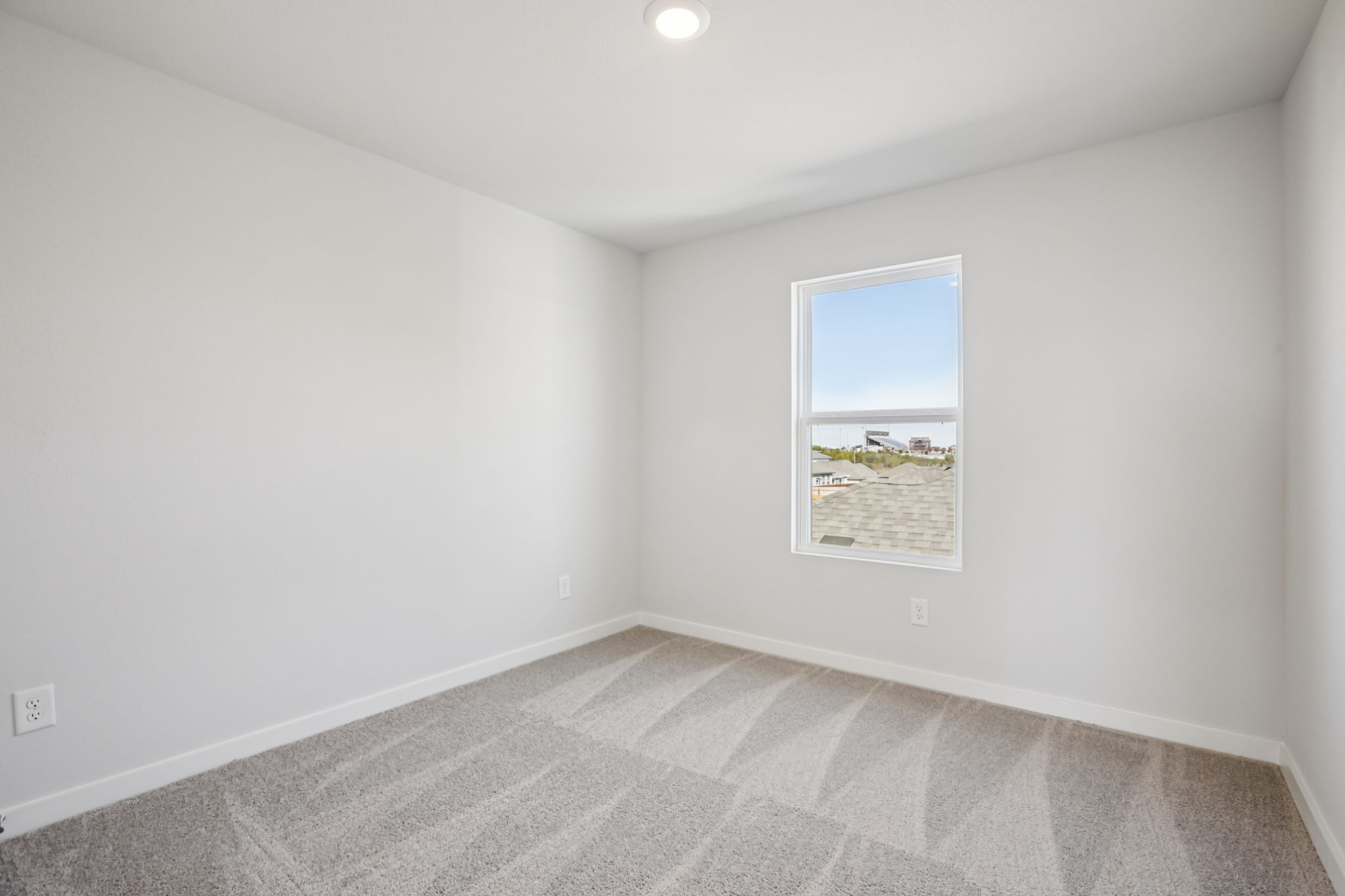 A room with a white wall and a window.