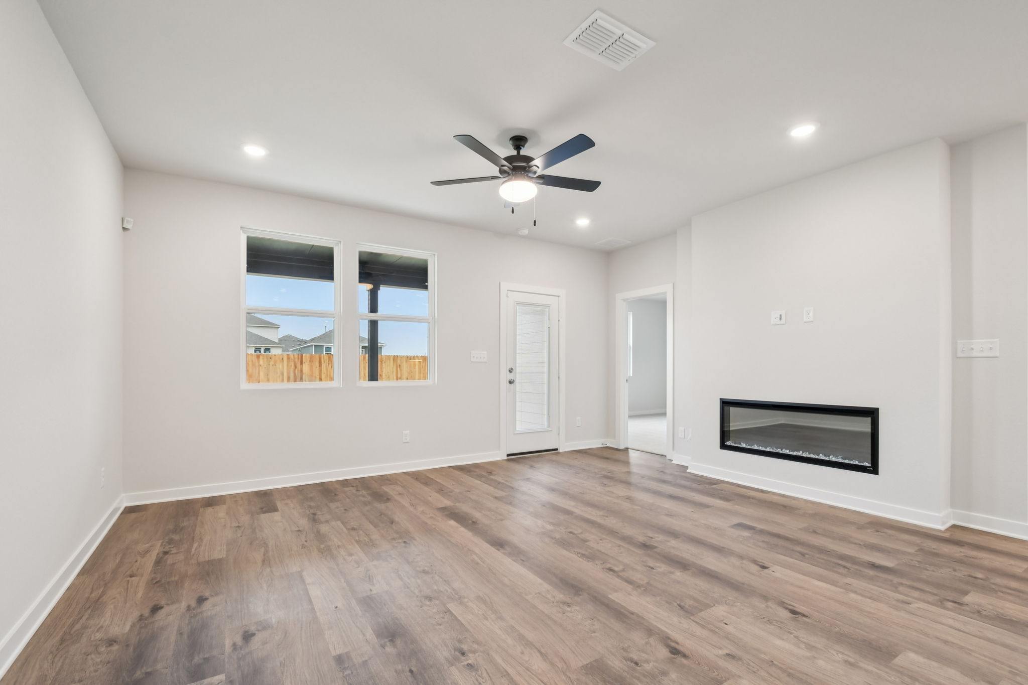 A room with a wood floor and a ceiling fan.