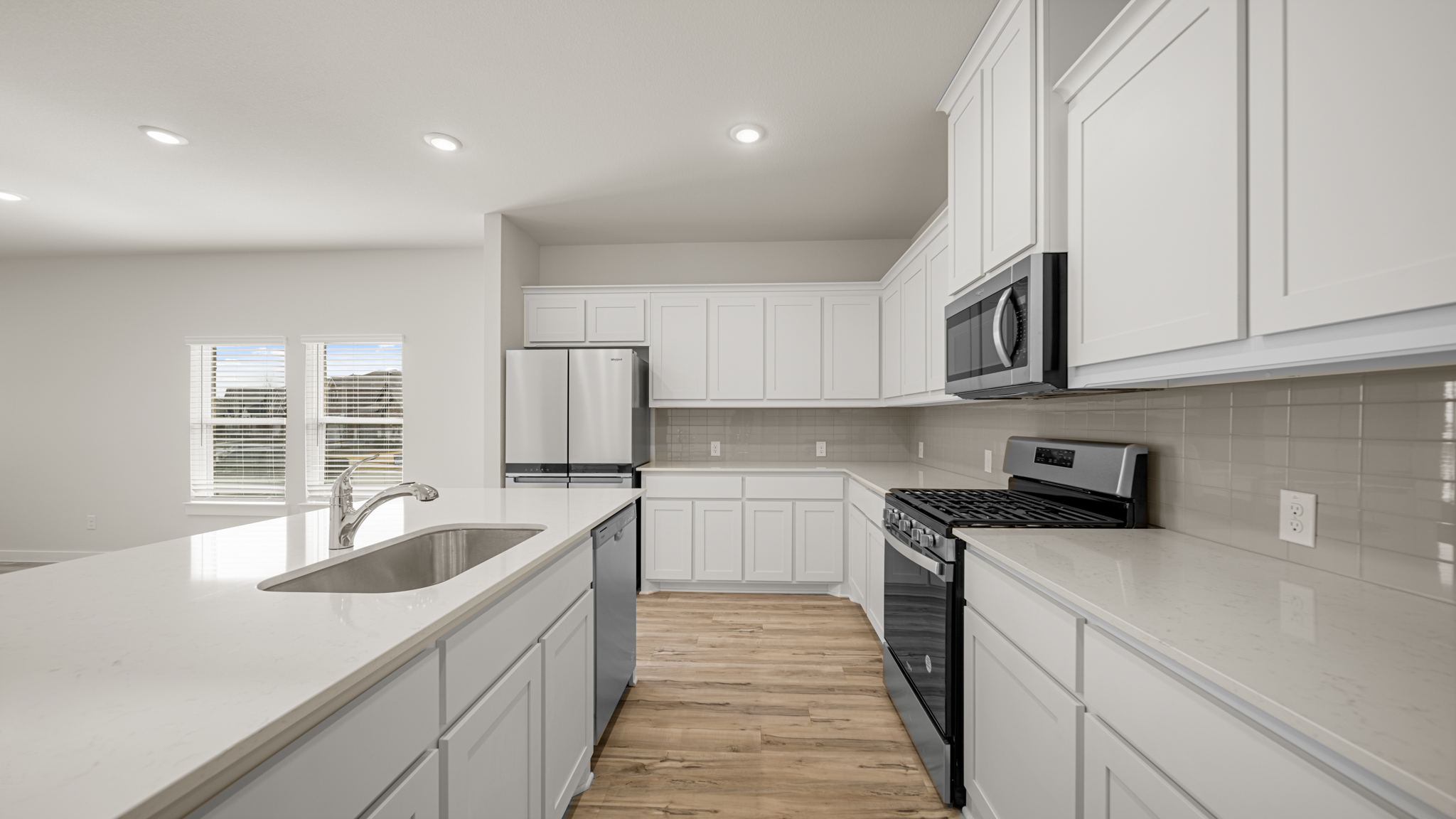 A kitchen with white cabinets.