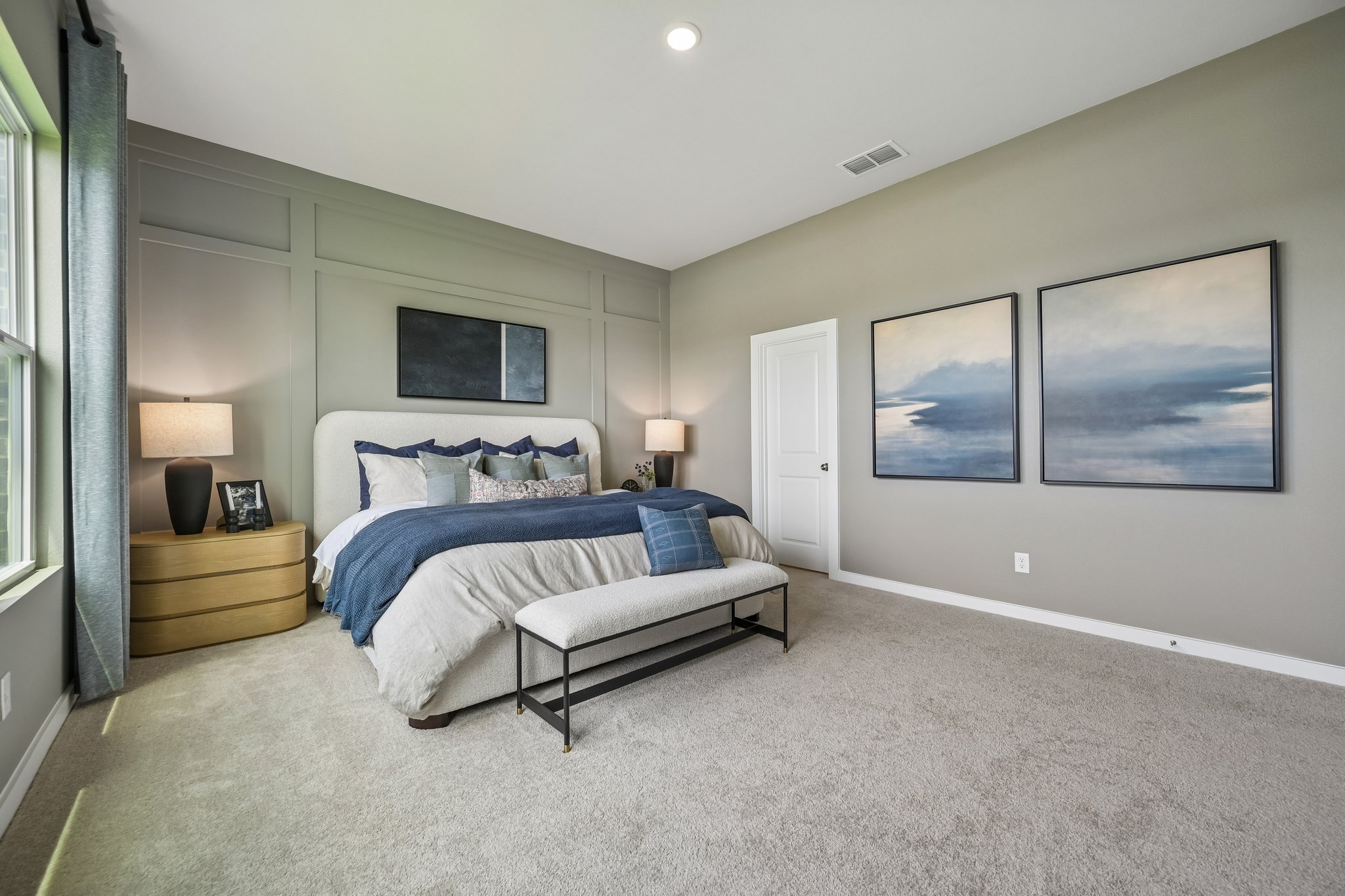 A bedroom with a bed and a bench.