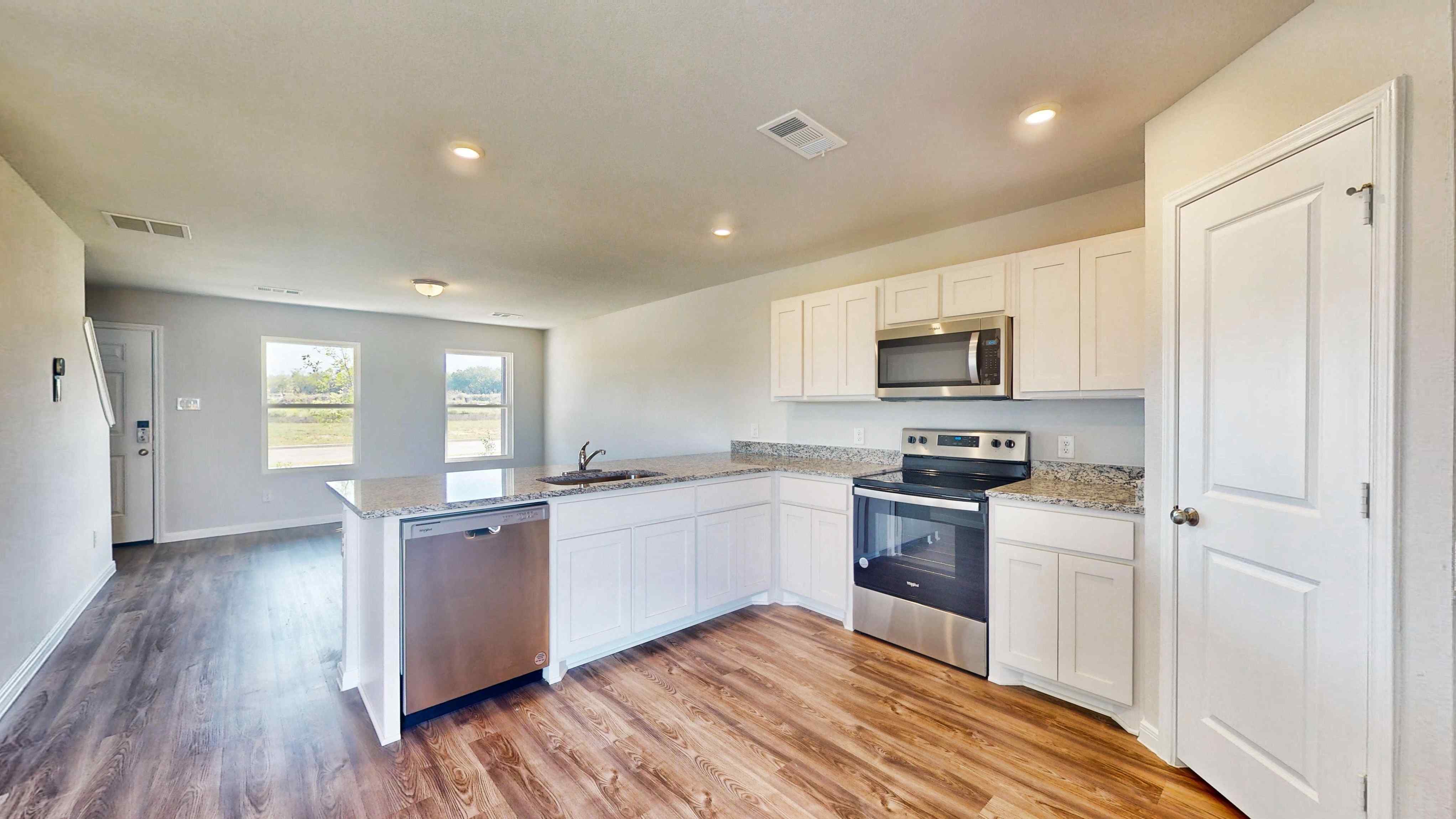 A kitchen with white cabinets.