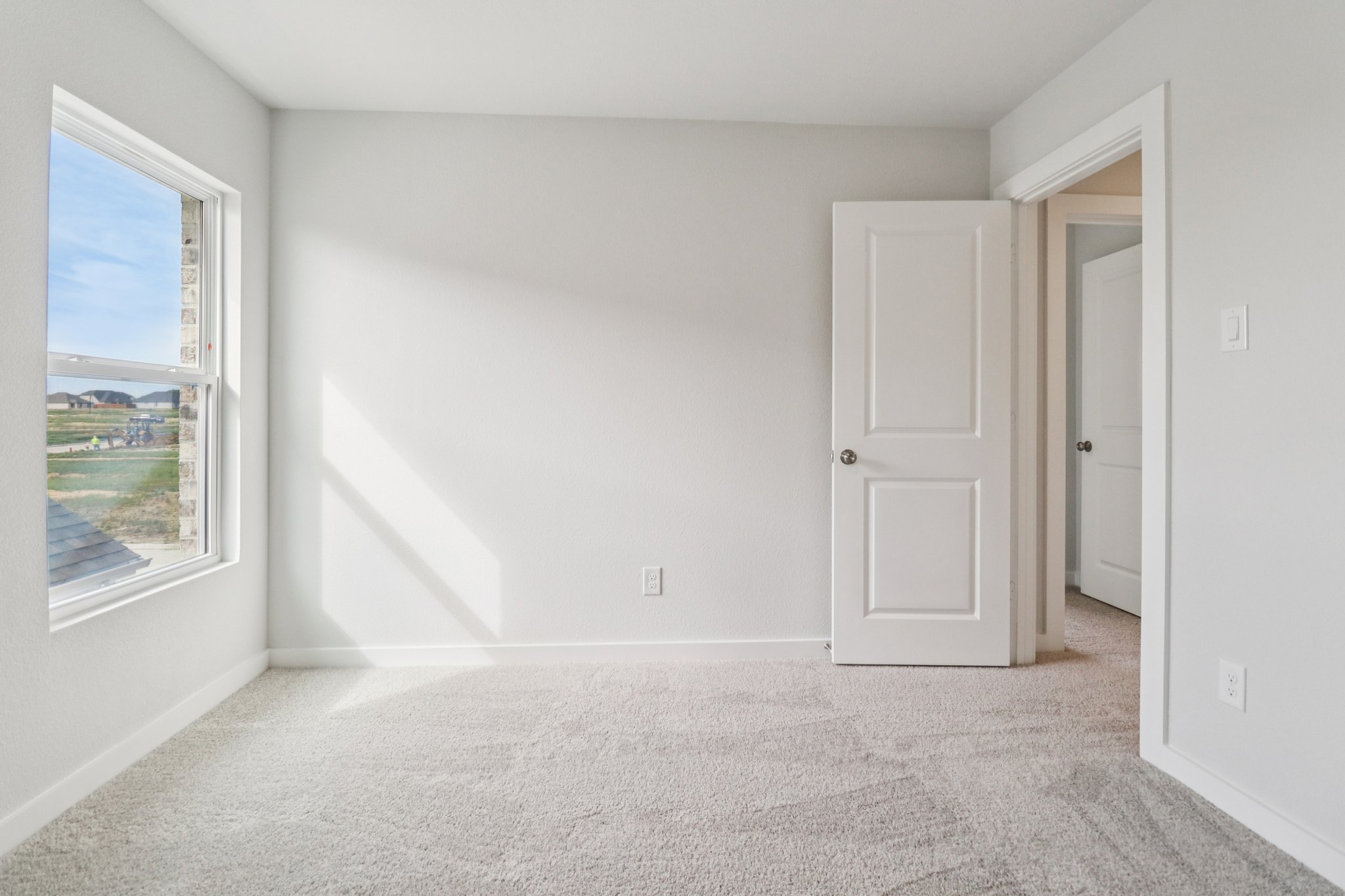 A room with white walls and a window.