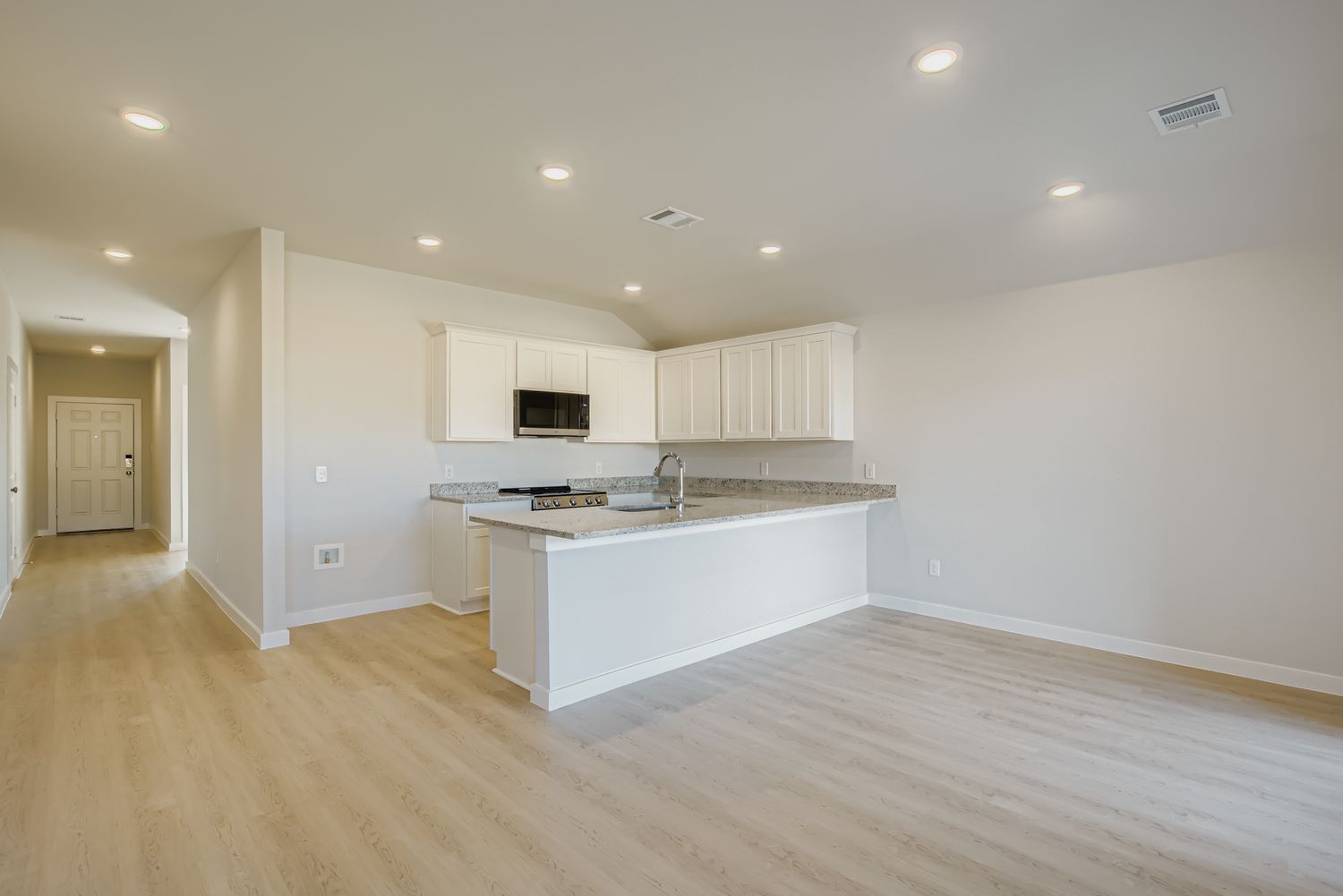 A kitchen with white cabinets.