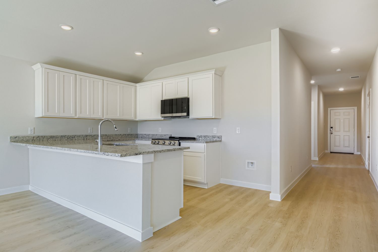 A kitchen with white cabinets.