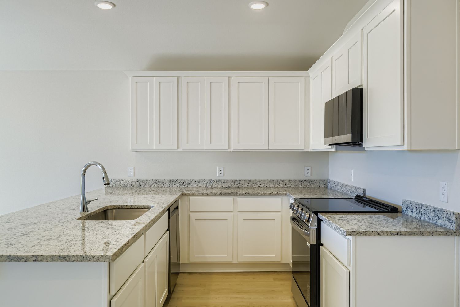 A kitchen with white cabinets.