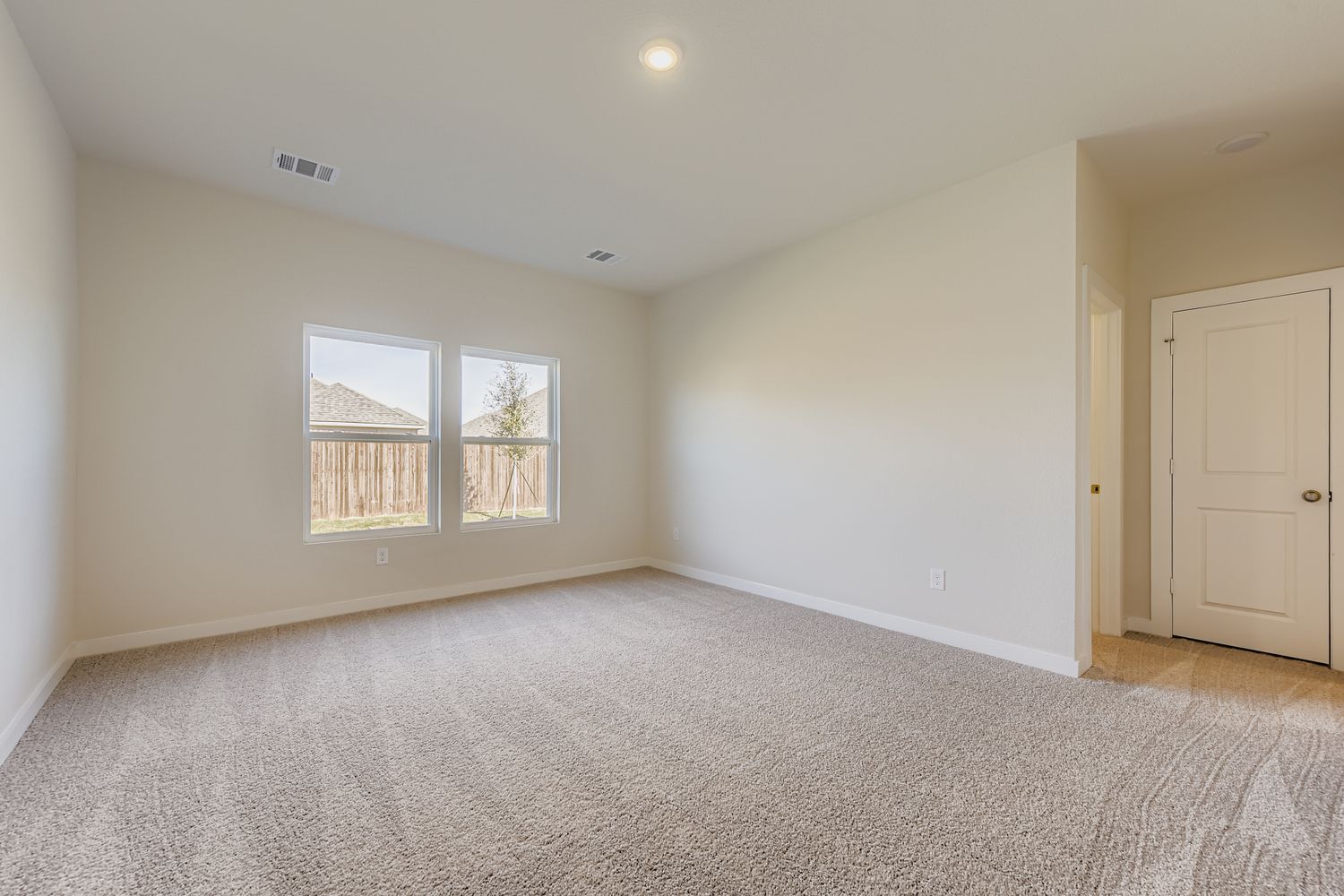 A room with a carpet and windows.