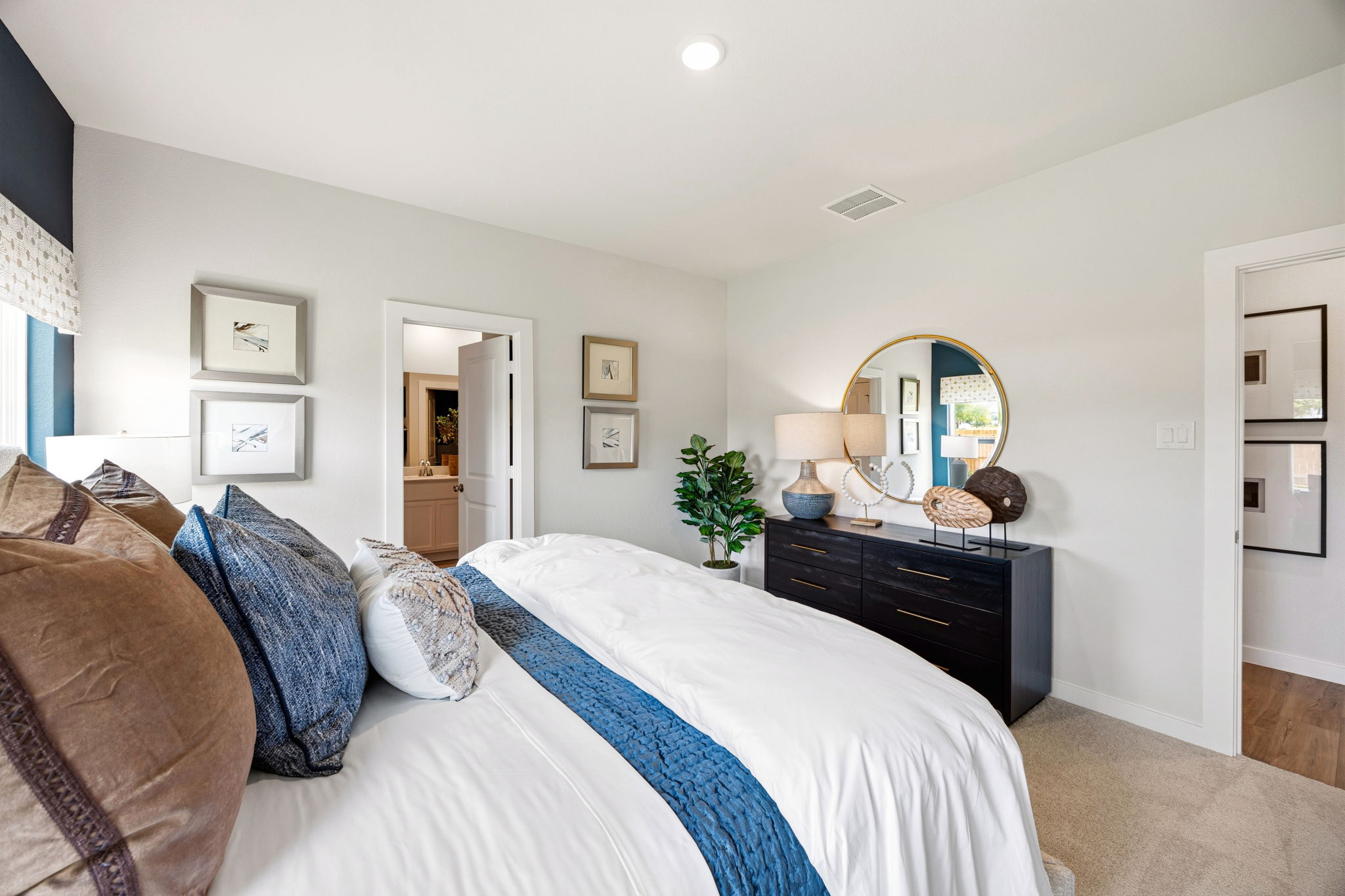 A bedroom with a bed and a mirror.