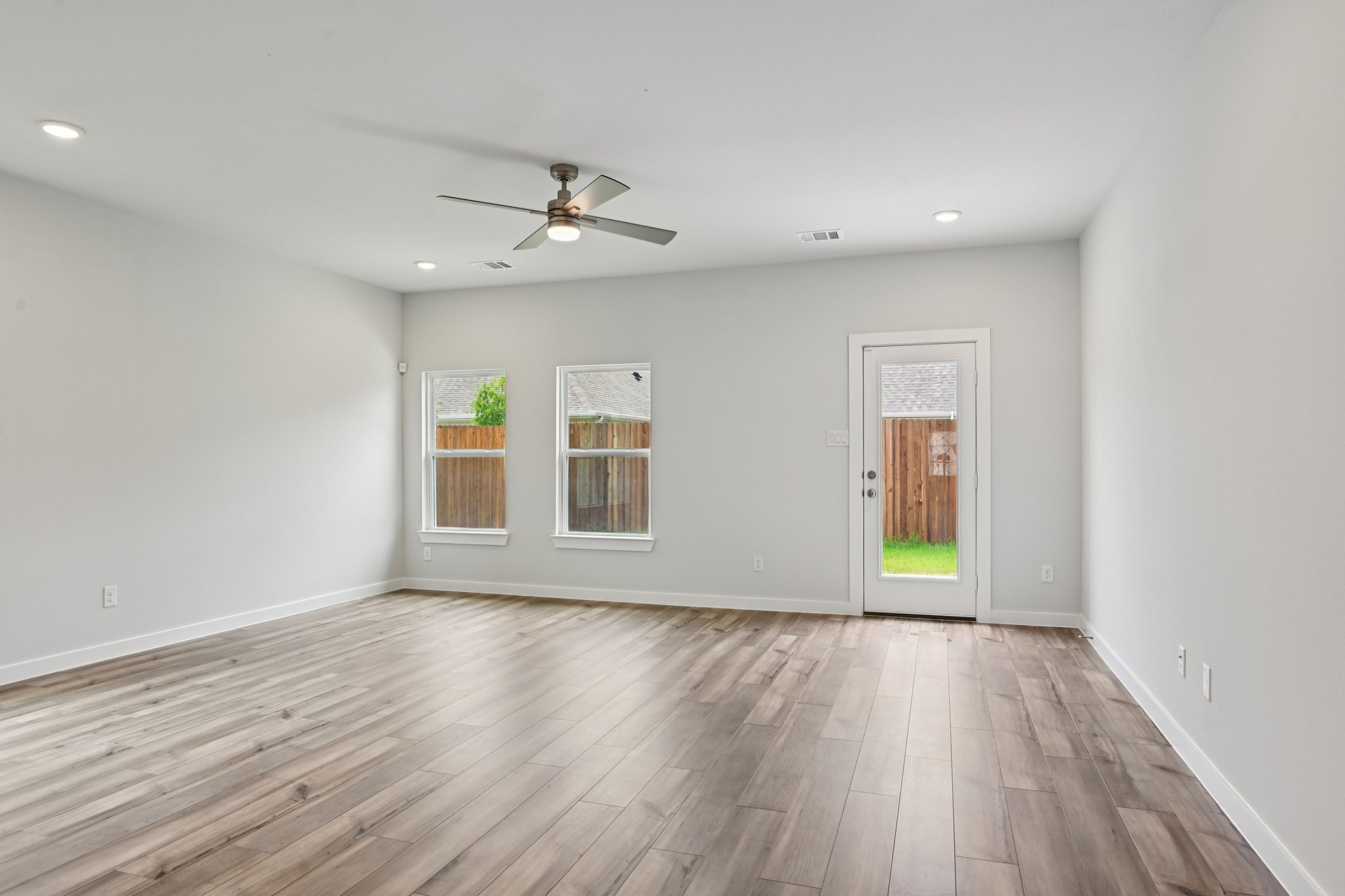 A room with a wood floor and a ceiling fan.