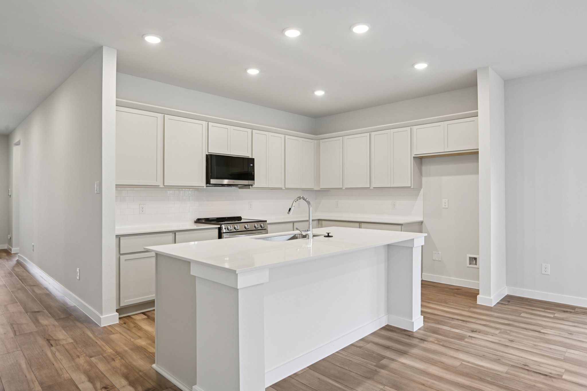 A kitchen with white cabinets.