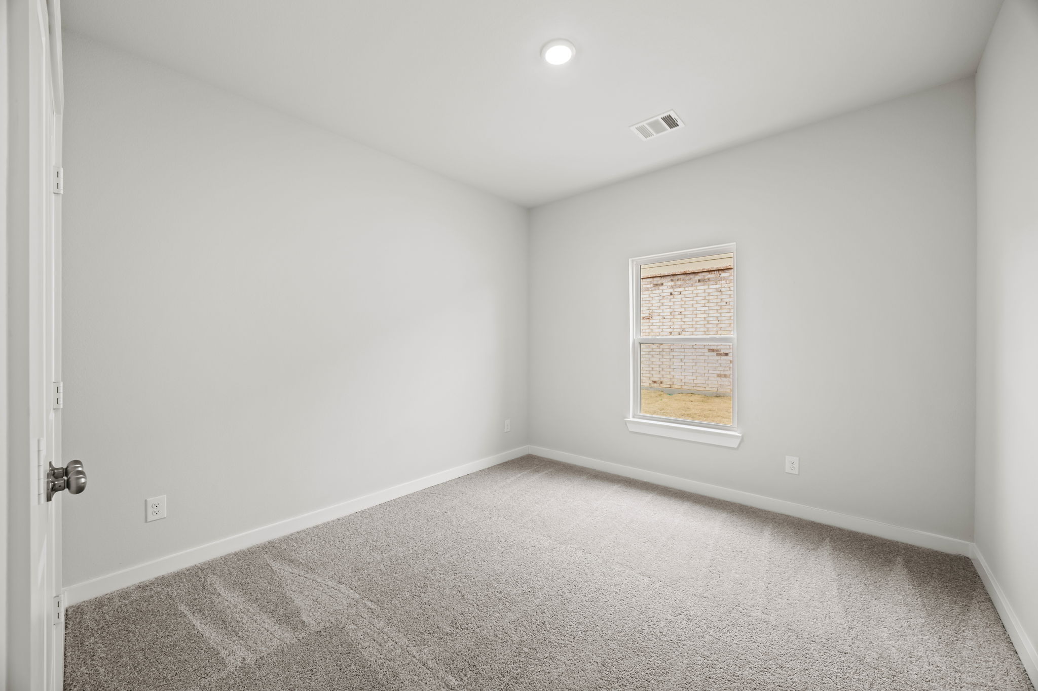A room with a carpet and a window.