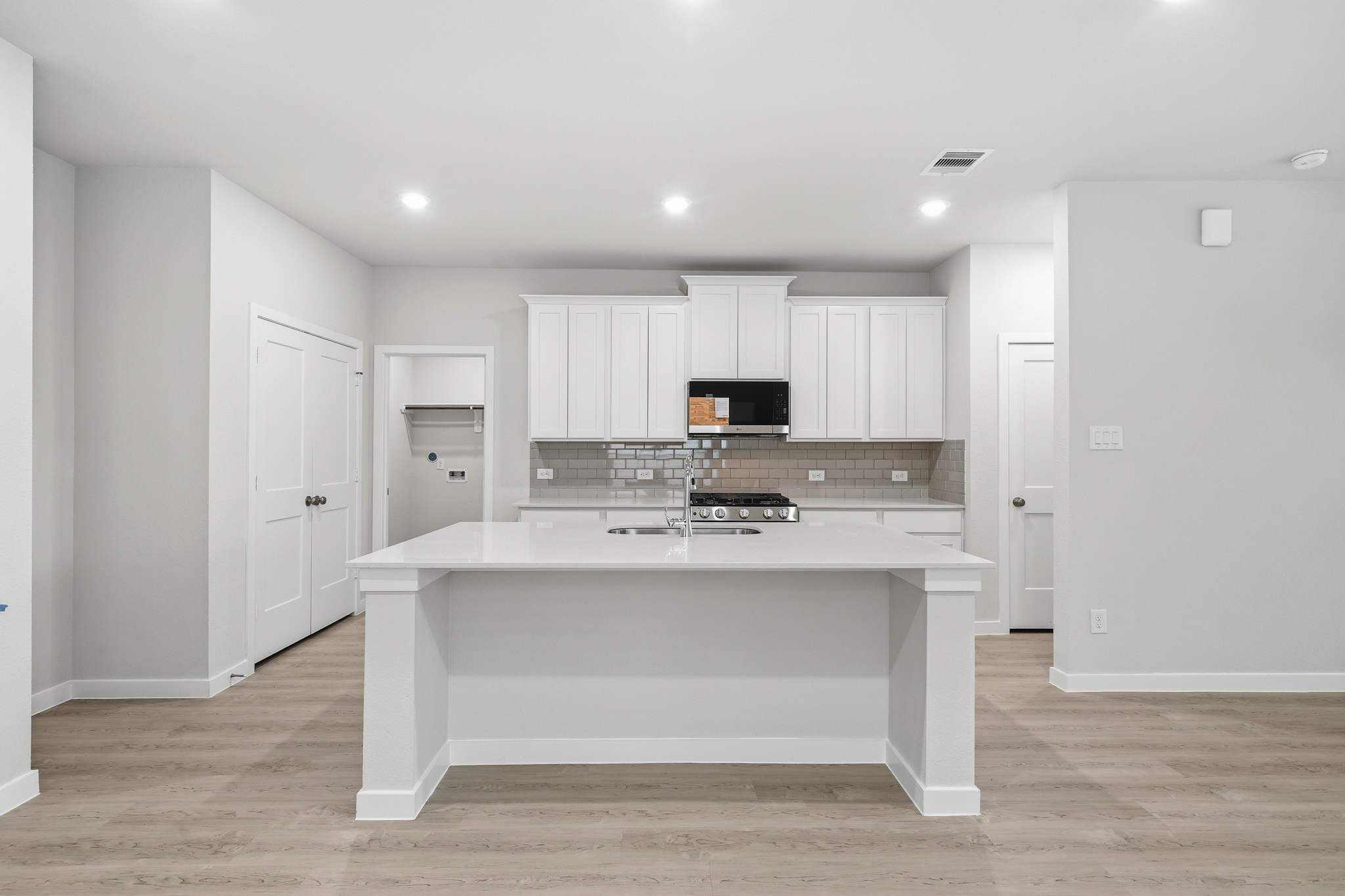 A kitchen with white cabinets.