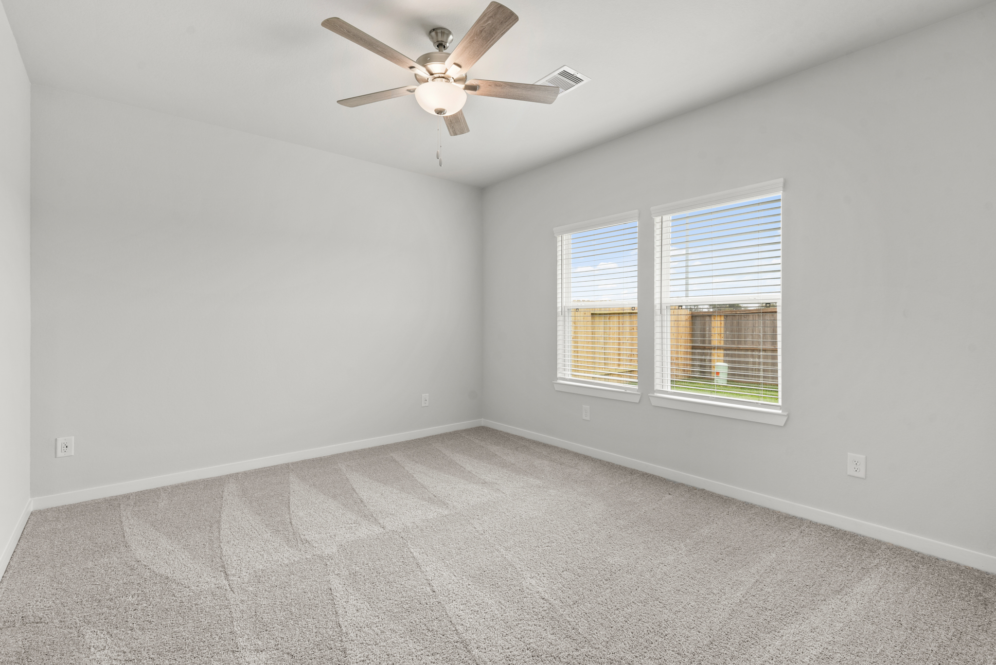 A room with a ceiling fan and a window.