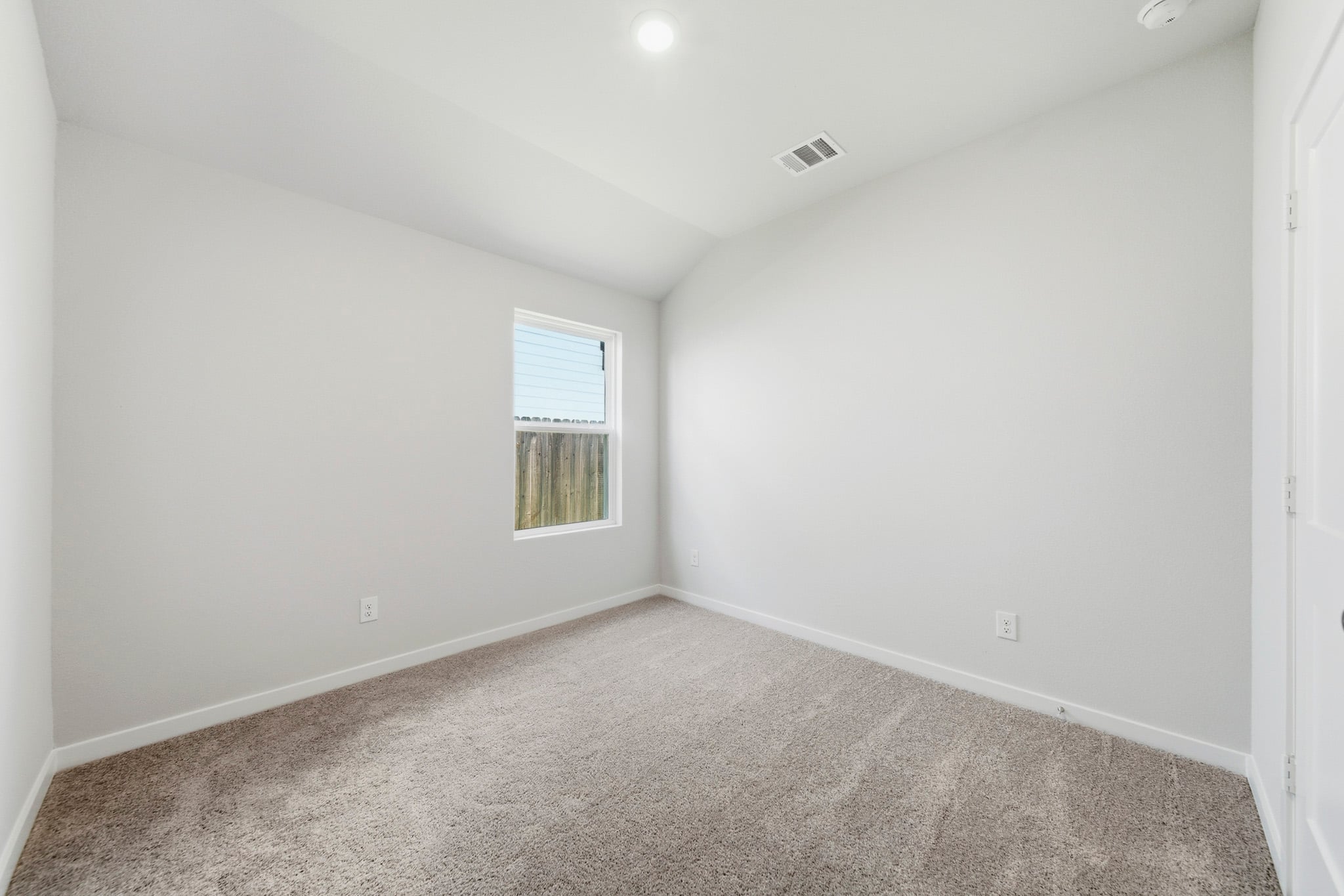 A room with a carpet and windows.