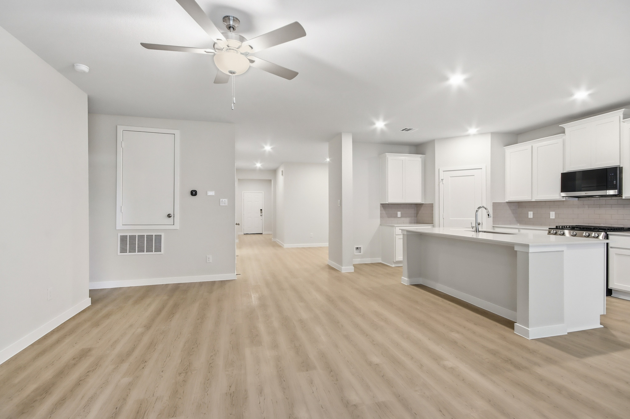 A kitchen with white cabinets.