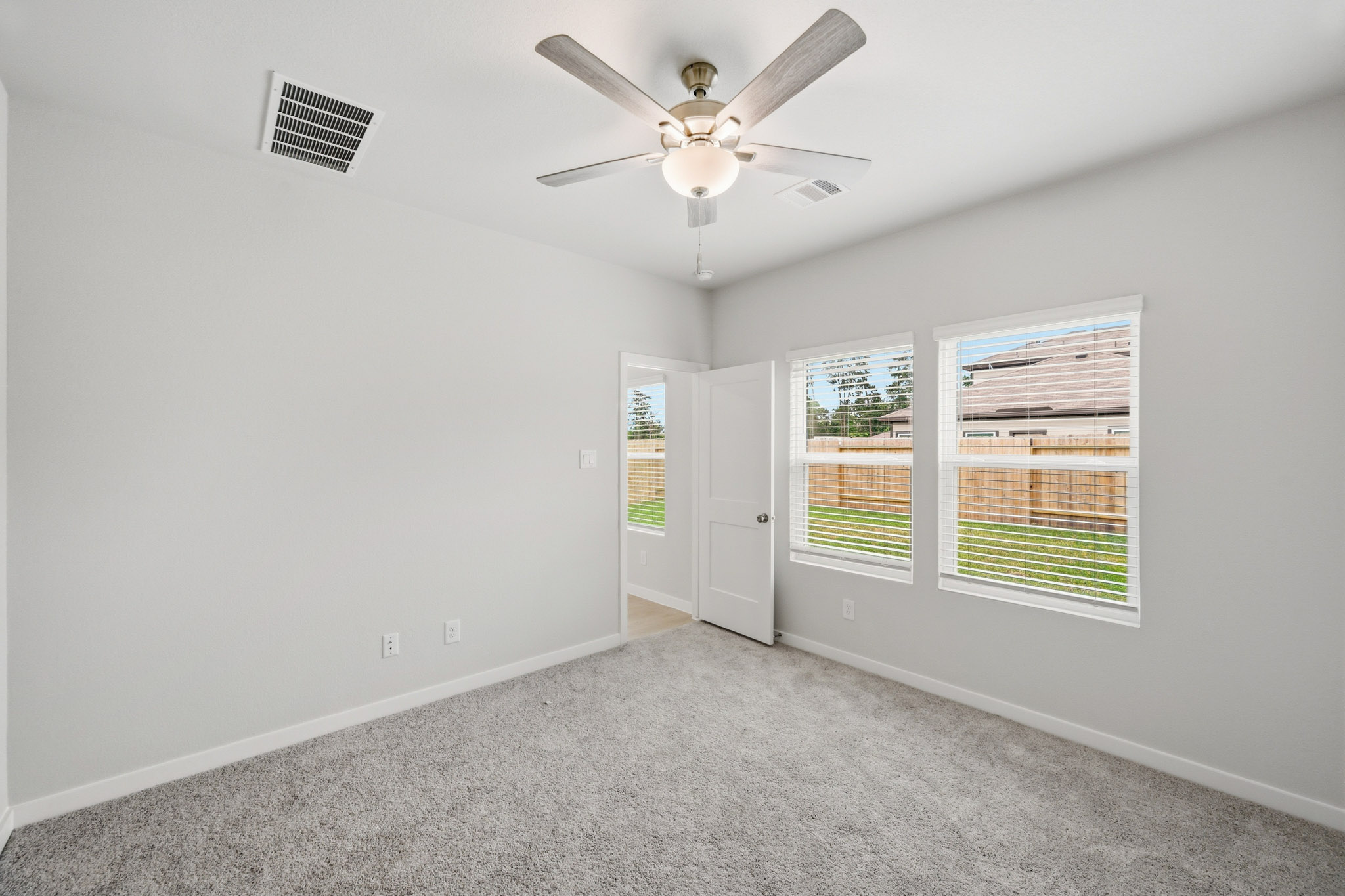 A room with a ceiling fan and a window.