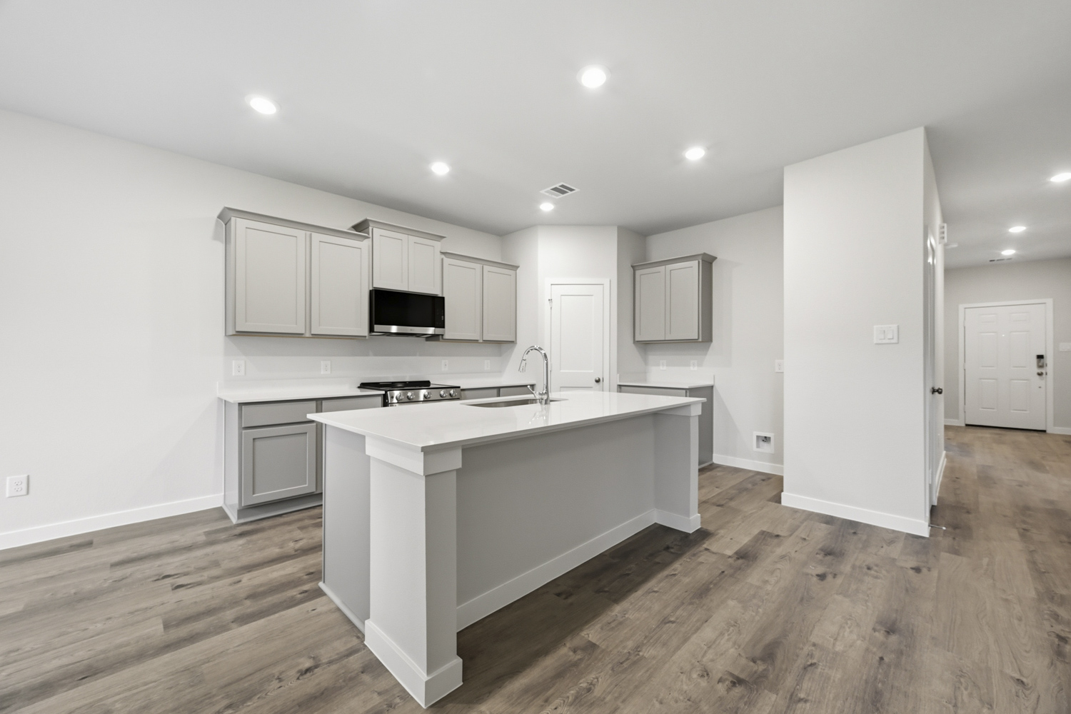 A kitchen with white cabinets.