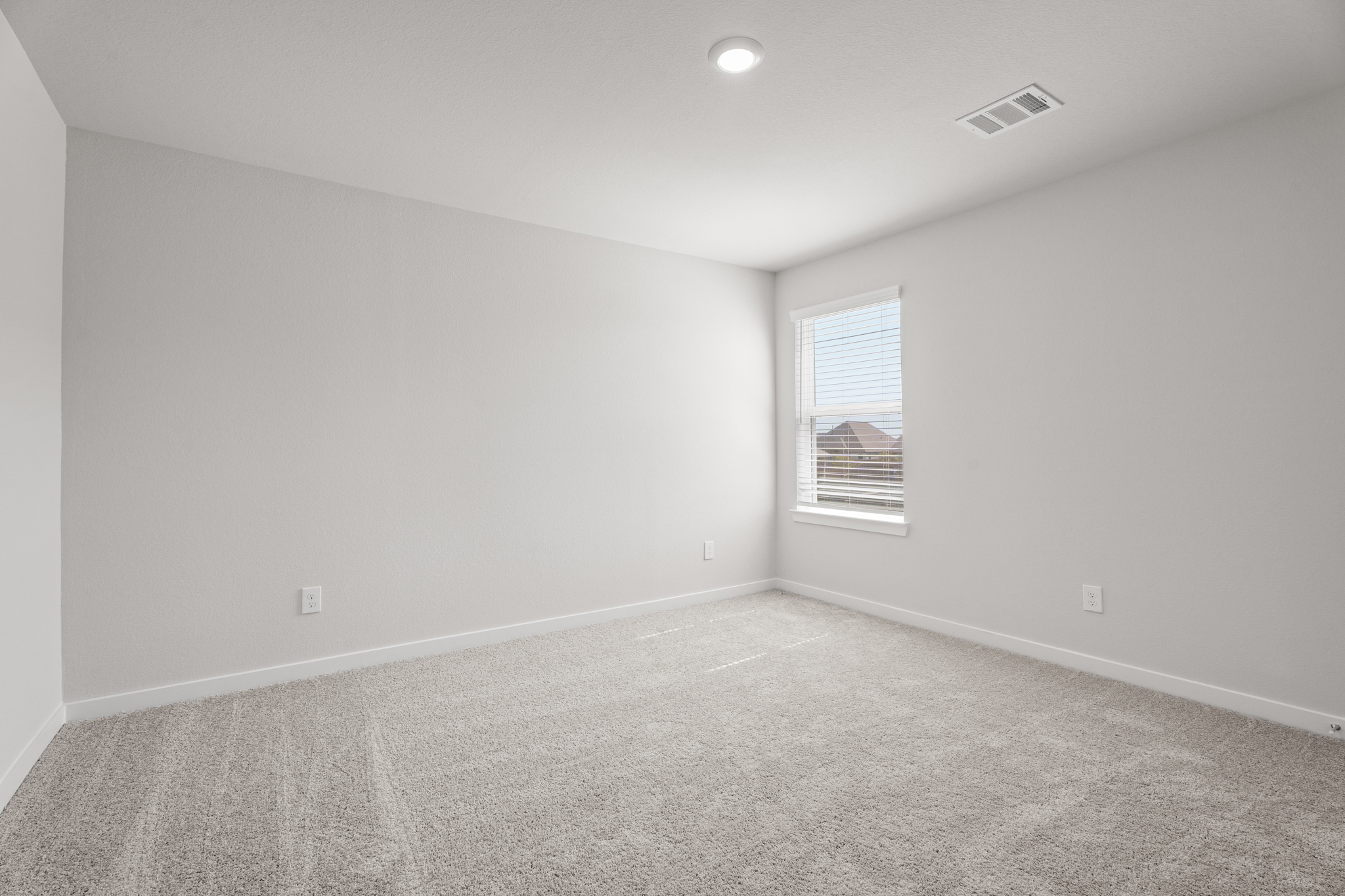 A room with a carpet and a window.