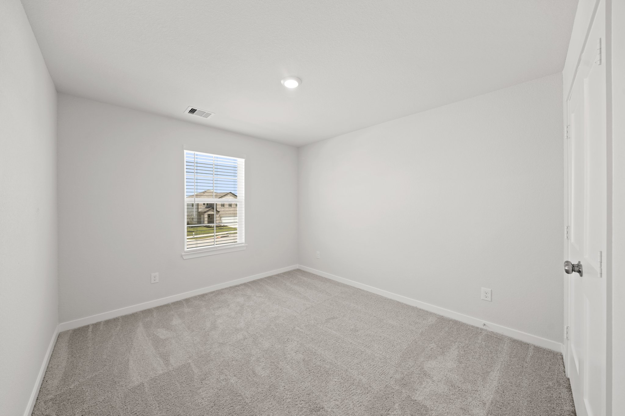 A room with a carpet and a window.