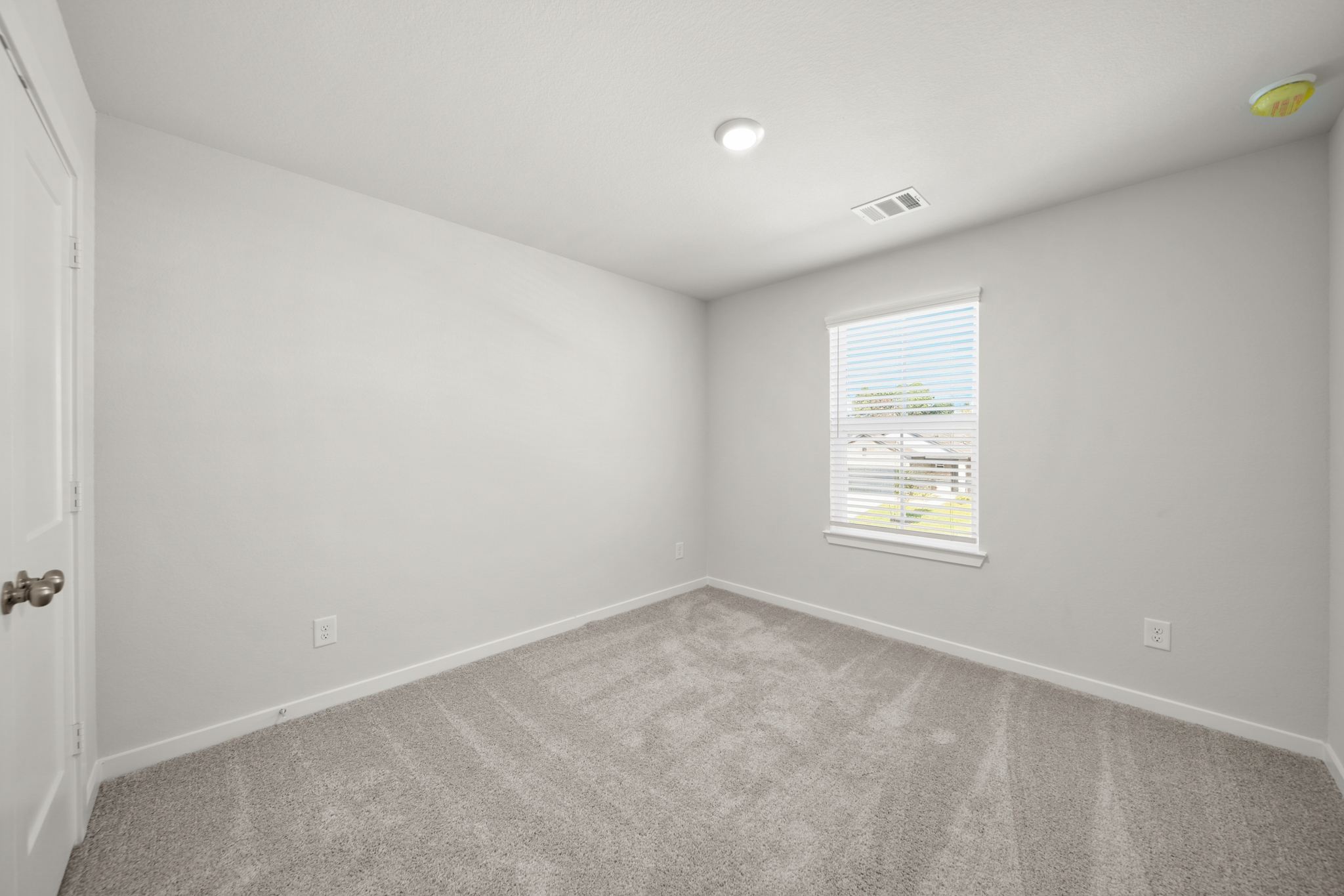 A room with a carpet and a window.