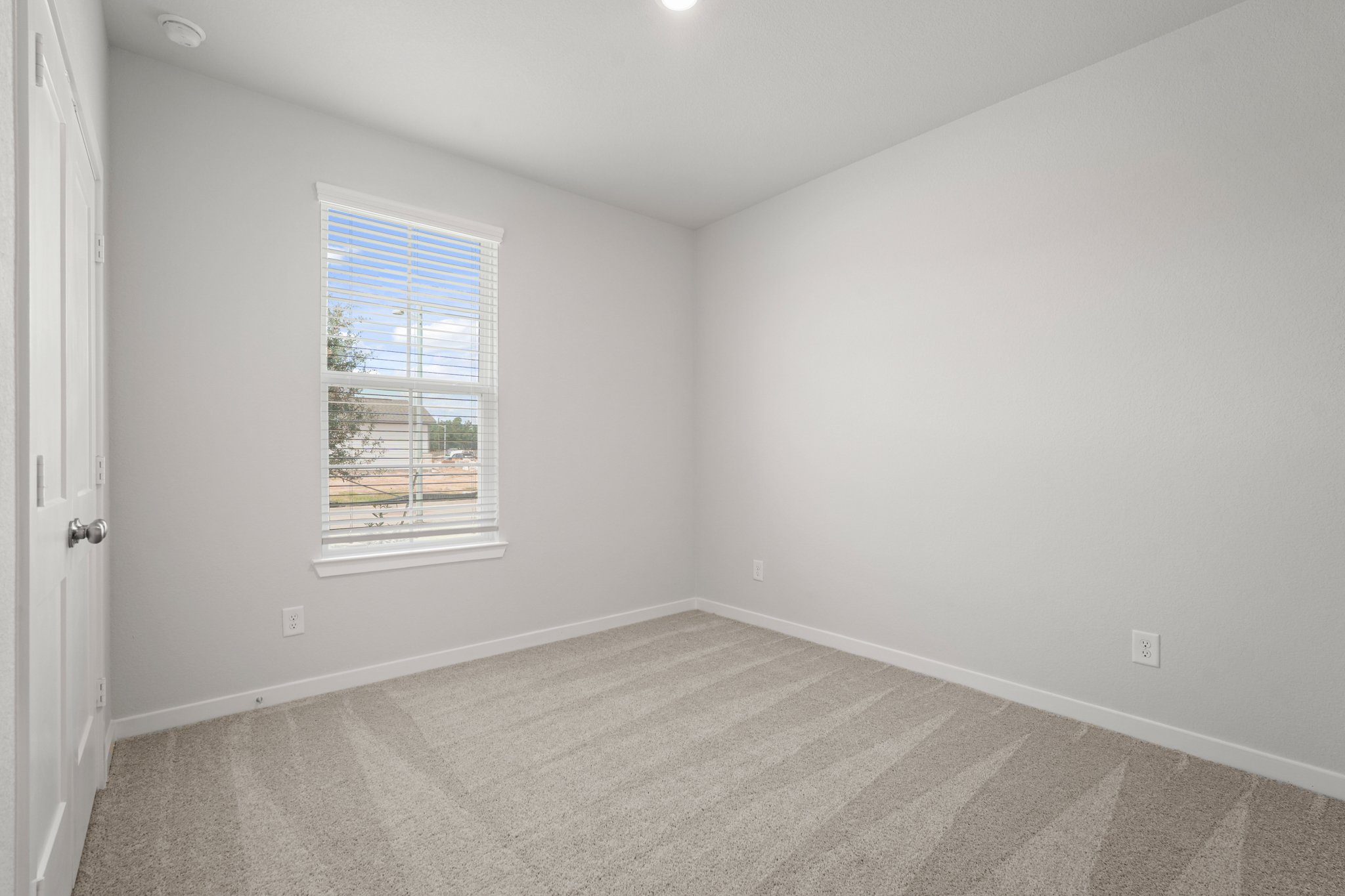 A room with a window and a rug.