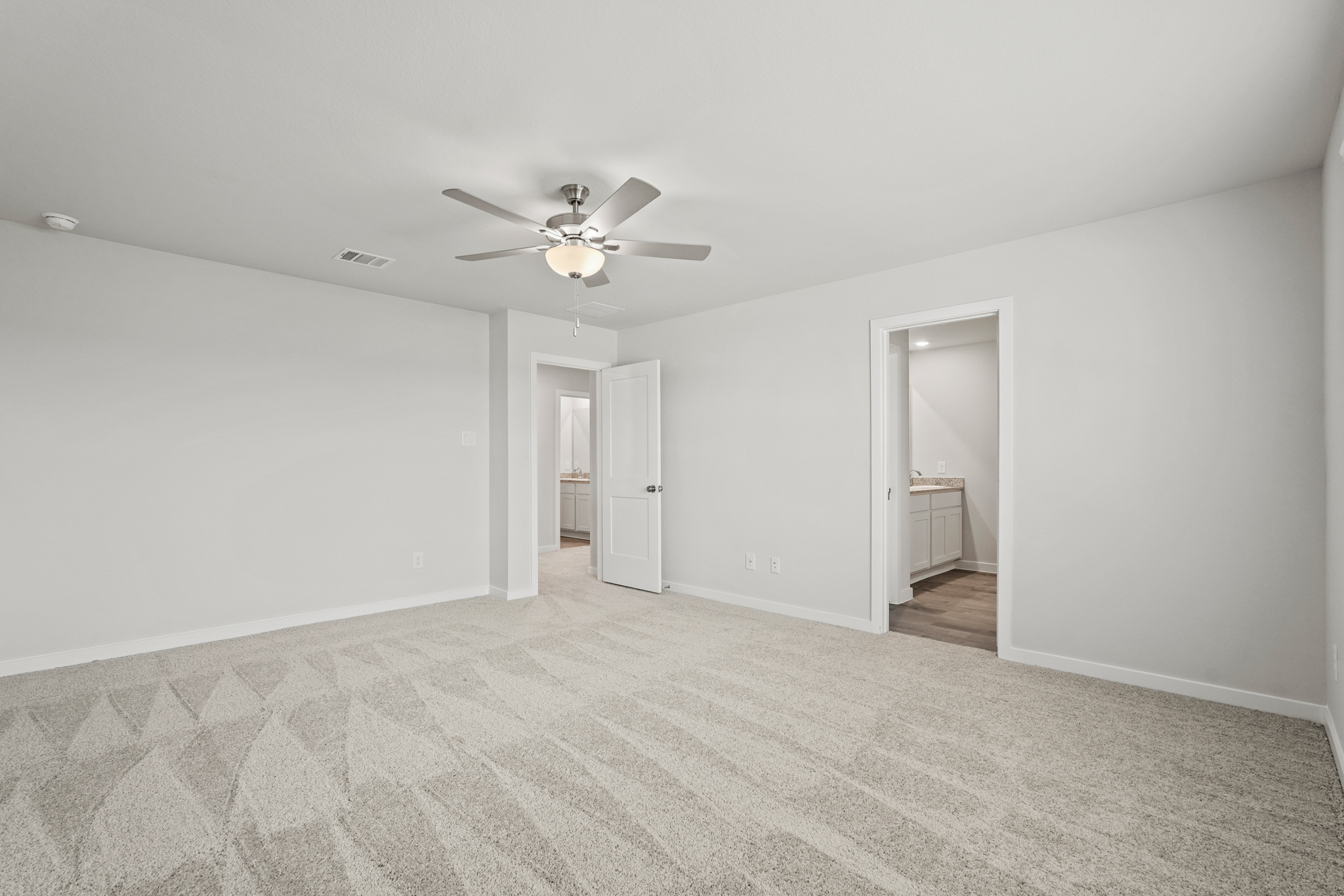 A room with a ceiling fan and a door.