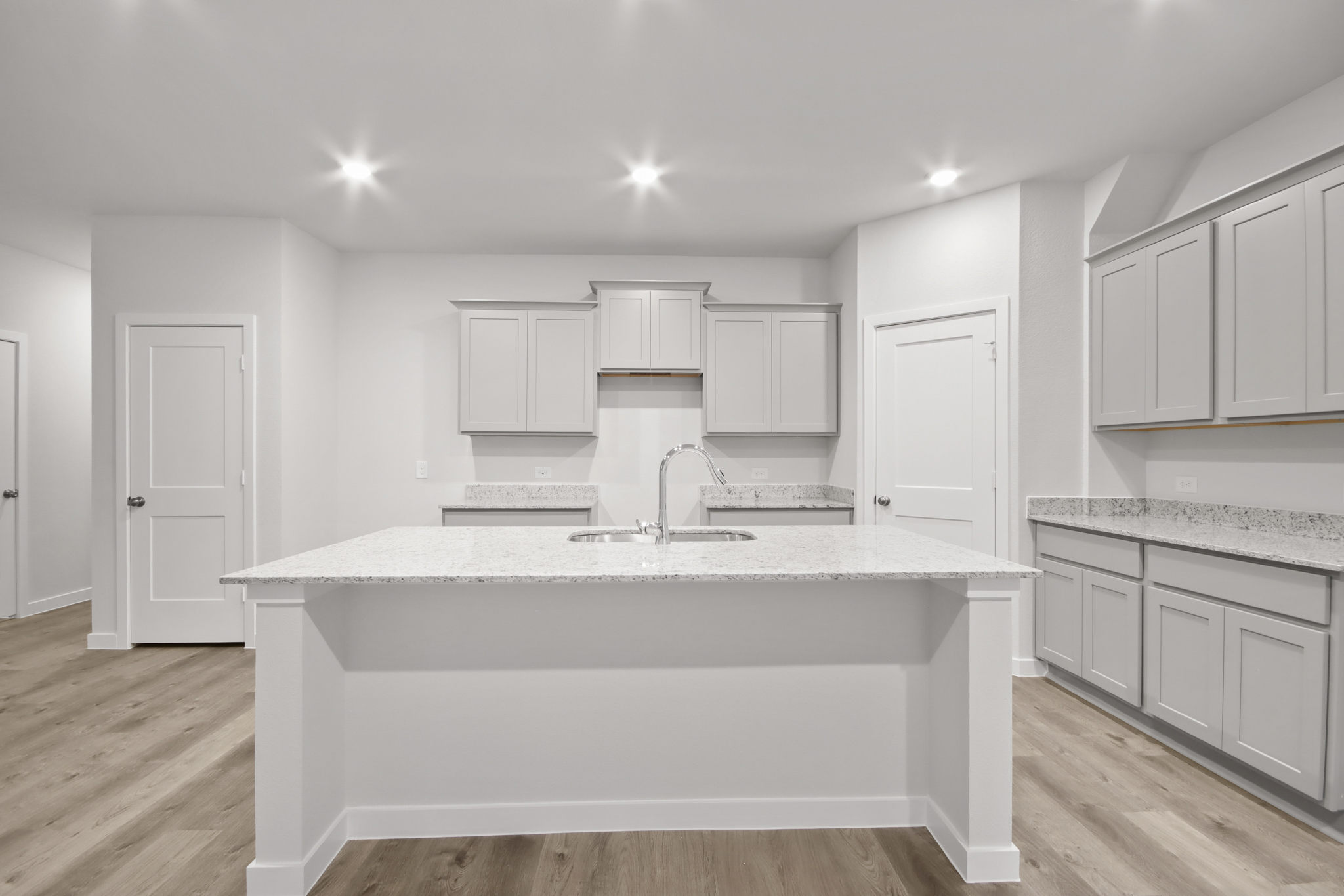 A kitchen with white cabinets.