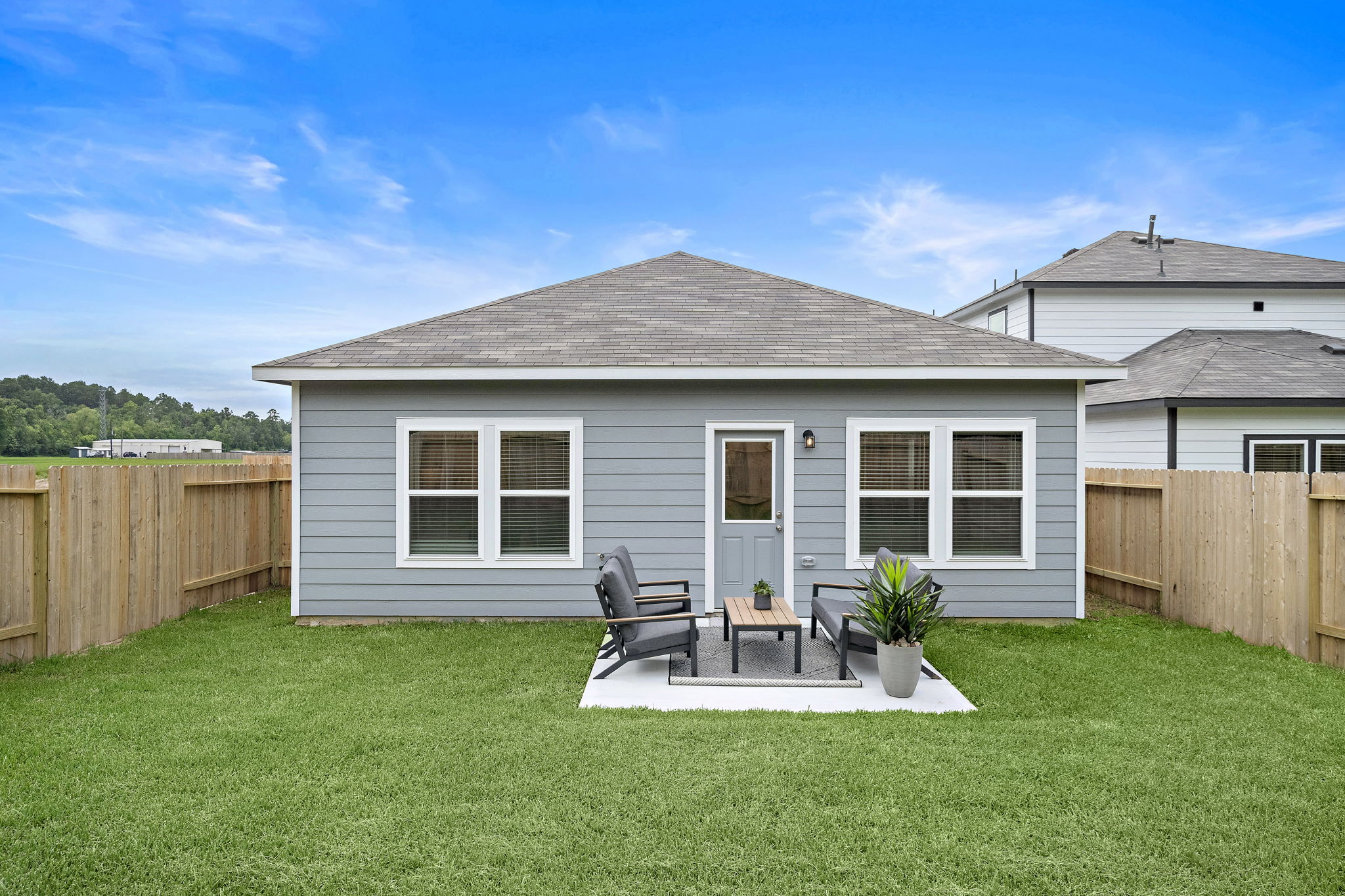 A house with a patio and a table and chairs in the front.
