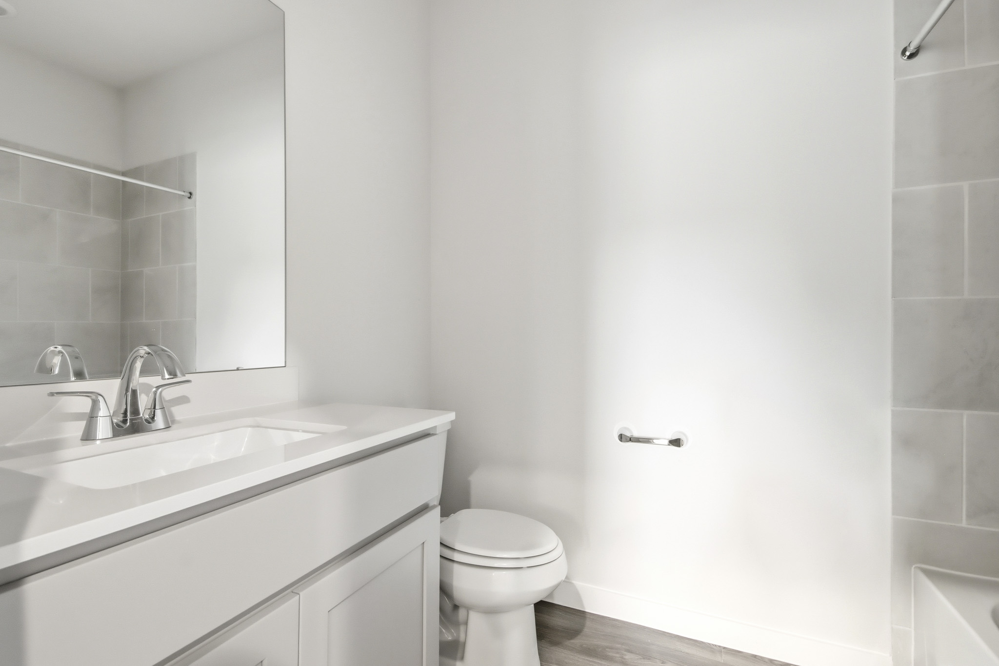 A bathroom with a sink toilet and mirror.