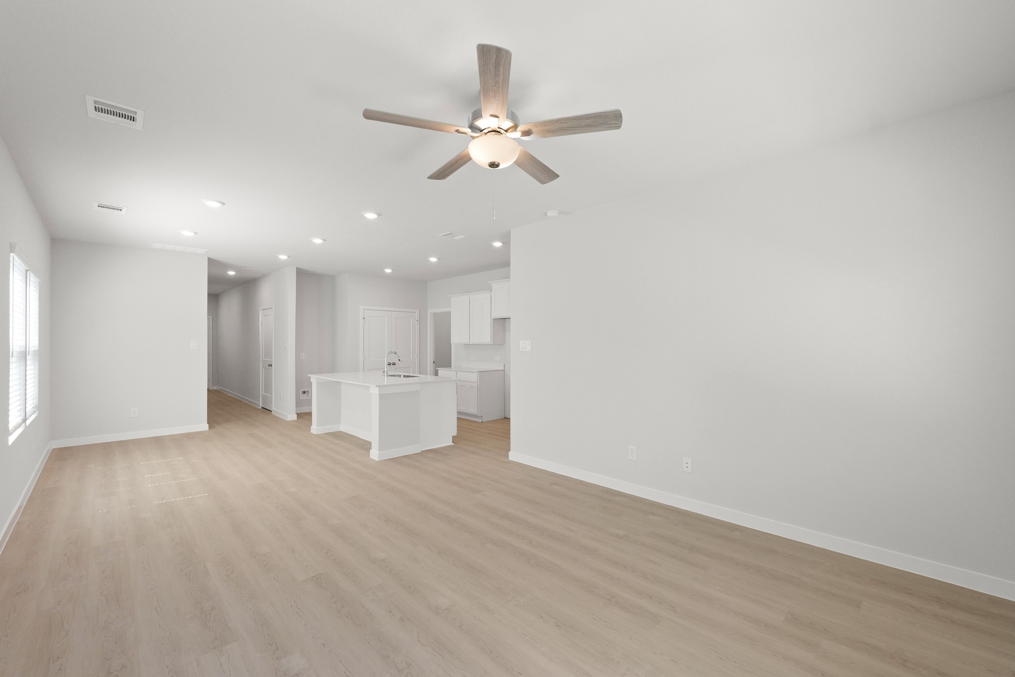 A room with a ceiling fan and a table.